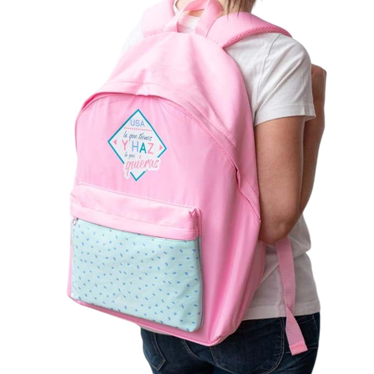 Una persona indossa uno zaino rosa con una tasca azzurra. Lo zaino ha una grafica USA con testo.