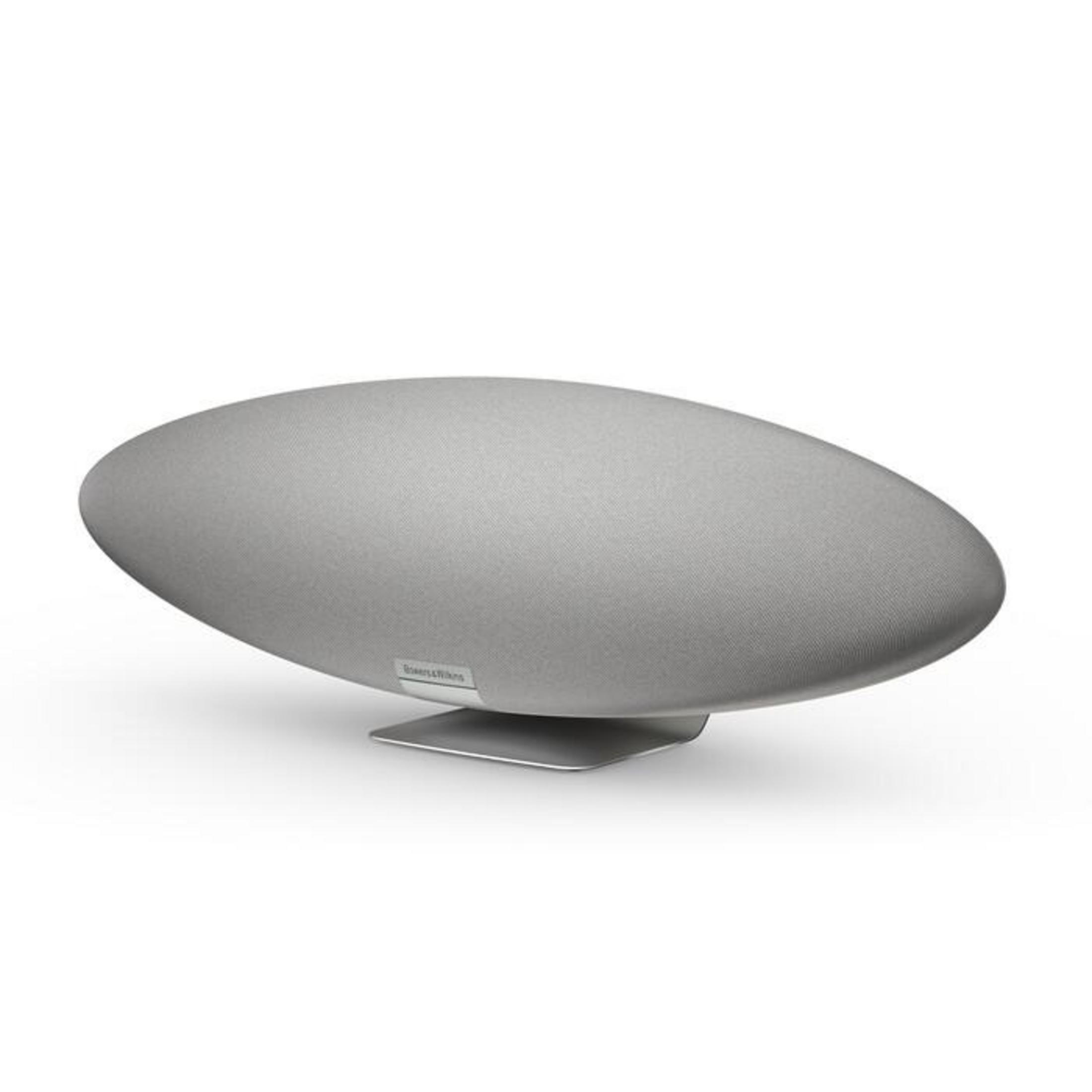 Ein grauer, oval geformter Lautsprecher mit einem silbernen Ständer. Der Lautsprecher ist mit dem Markennamen beschriftet.