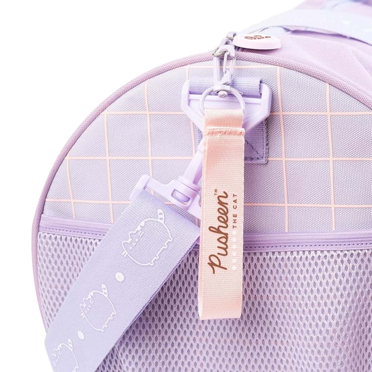 Nahaufnahme einer lila Pusheen-Reisetasche. Sie hat einen hellrosa Gurt mit dem Pusheen-Logo und eine Netztasche.