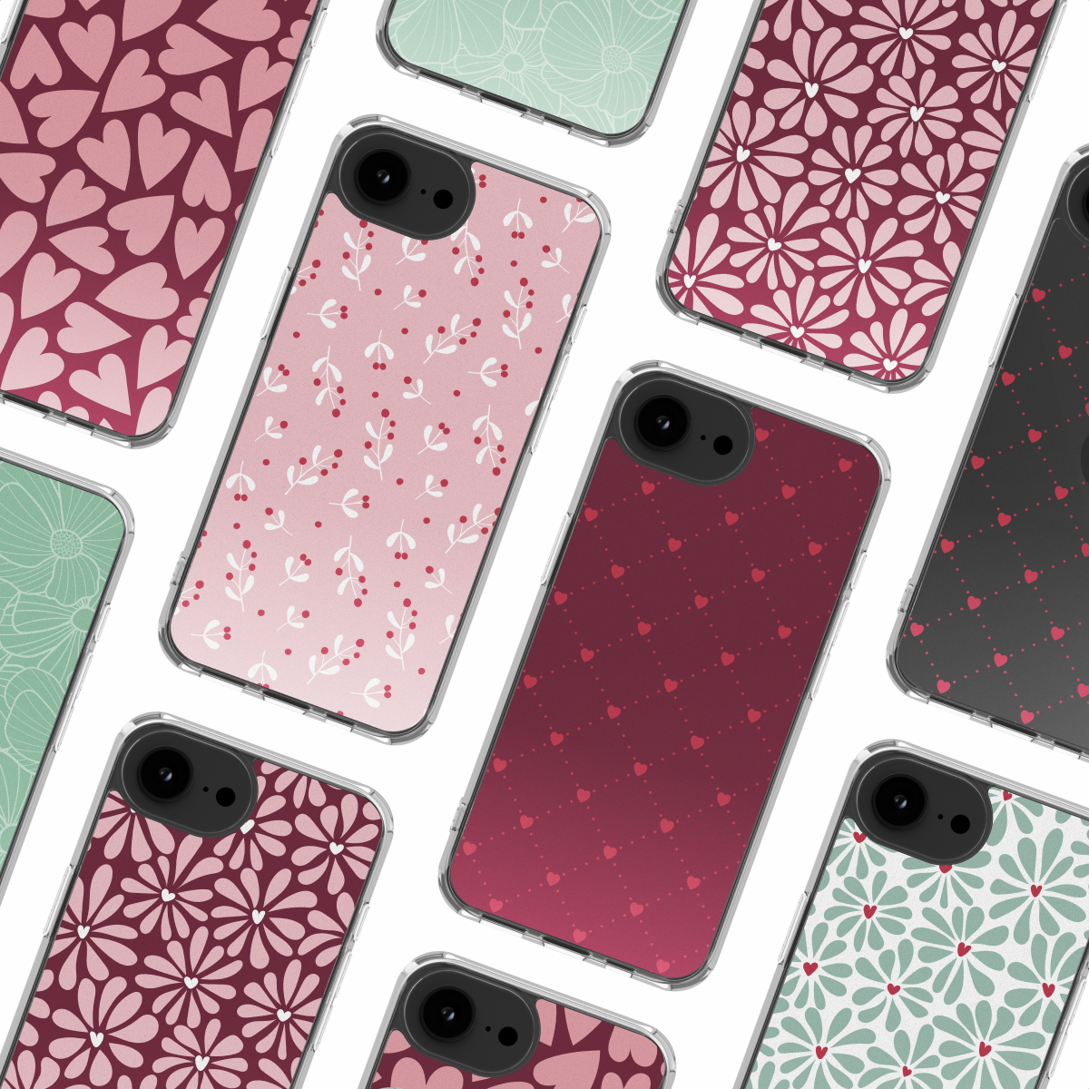 Diverse custodie per telefono con vari motivi di cuori, fiori e foglie in tonalità rosa, rosso e verde, disposte su una superficie bianca.