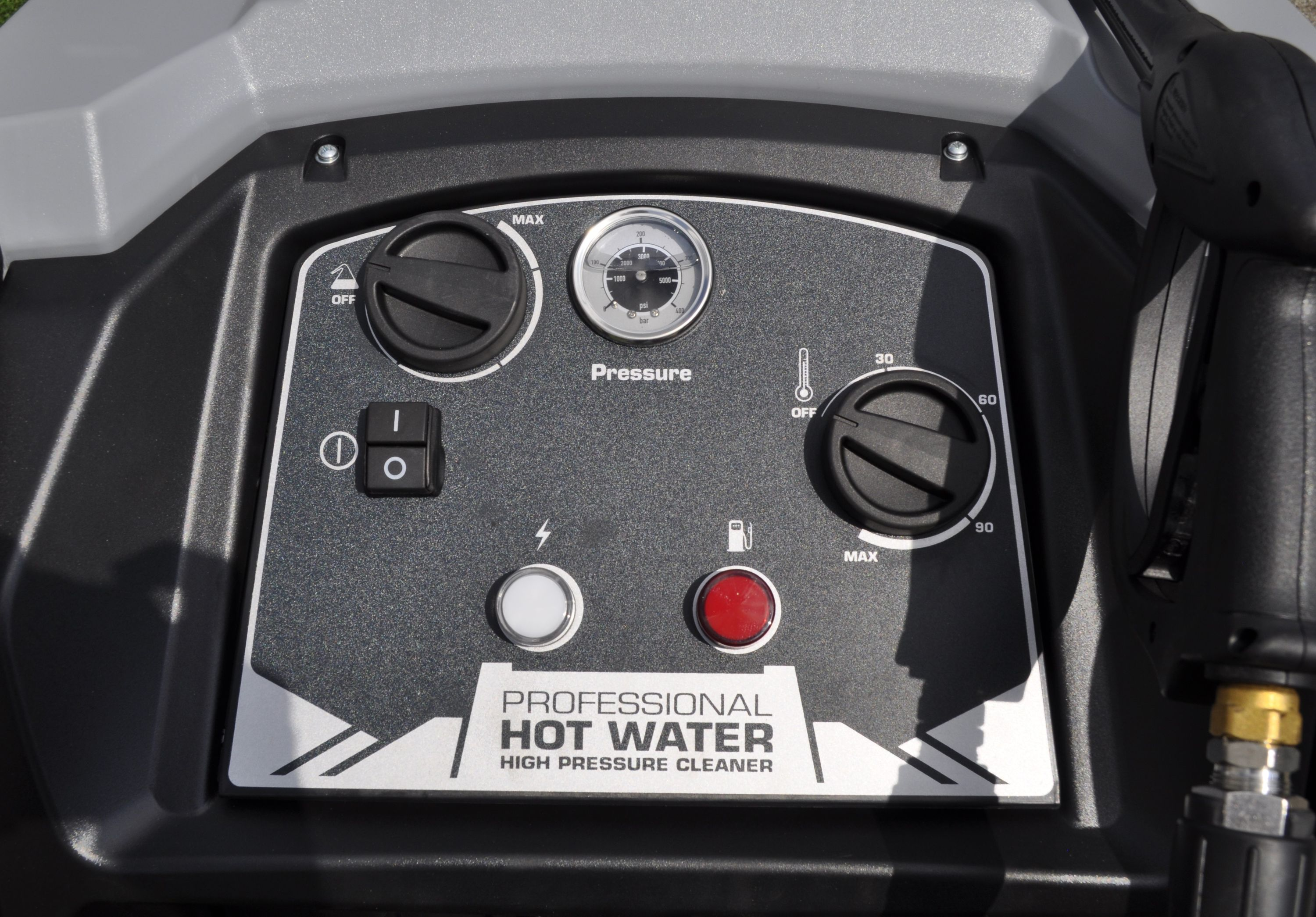 Nahaufnahme eines Bedienfelds eines Hochdruckreinigers. Enthält Anzeigen, Knöpfe und Zifferblätter und den Text 'HOT WATER'.
