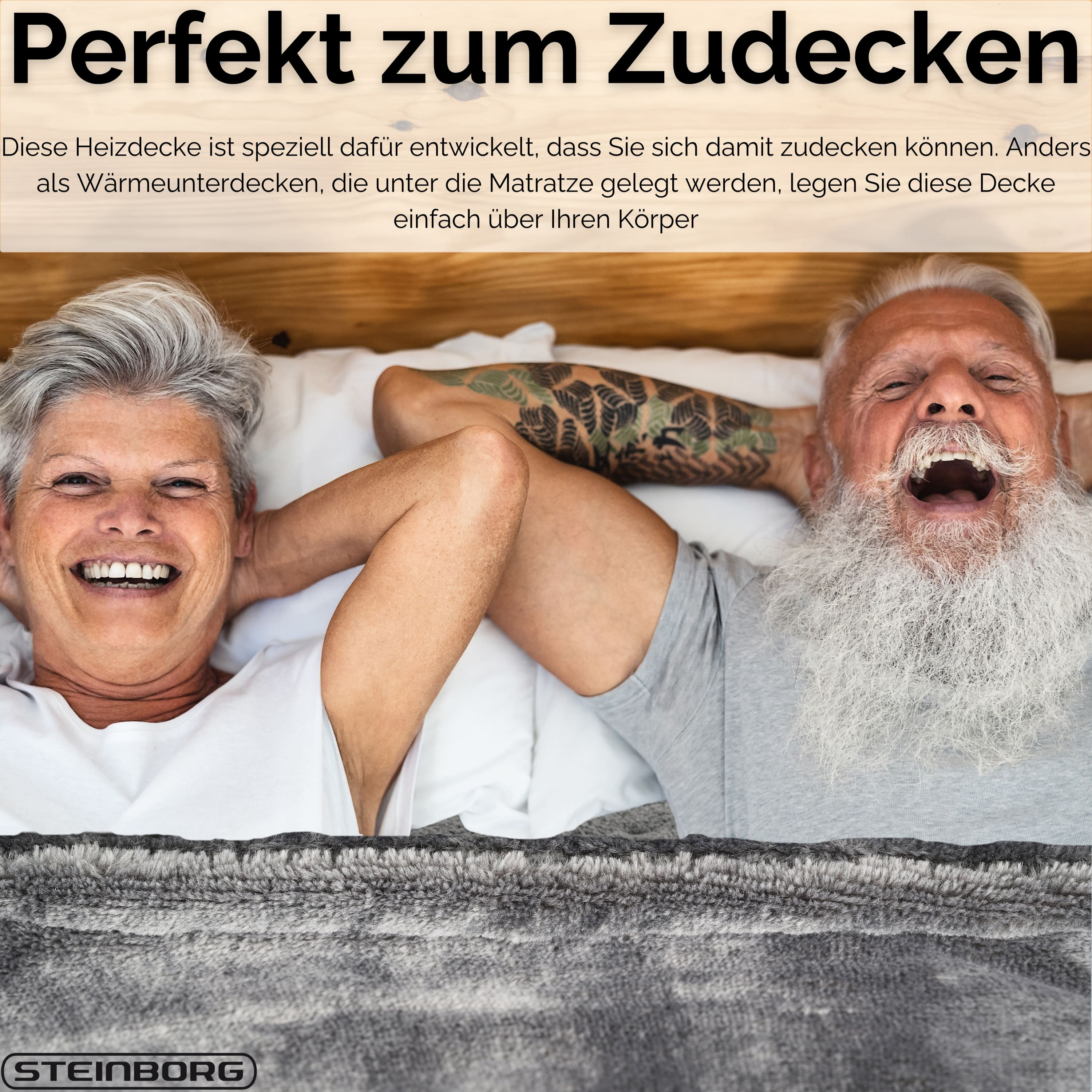 Ein älteres Ehepaar lächelt im Bett. Der Mann hat ein Tattoo. Eine Decke bedeckt das Bett.