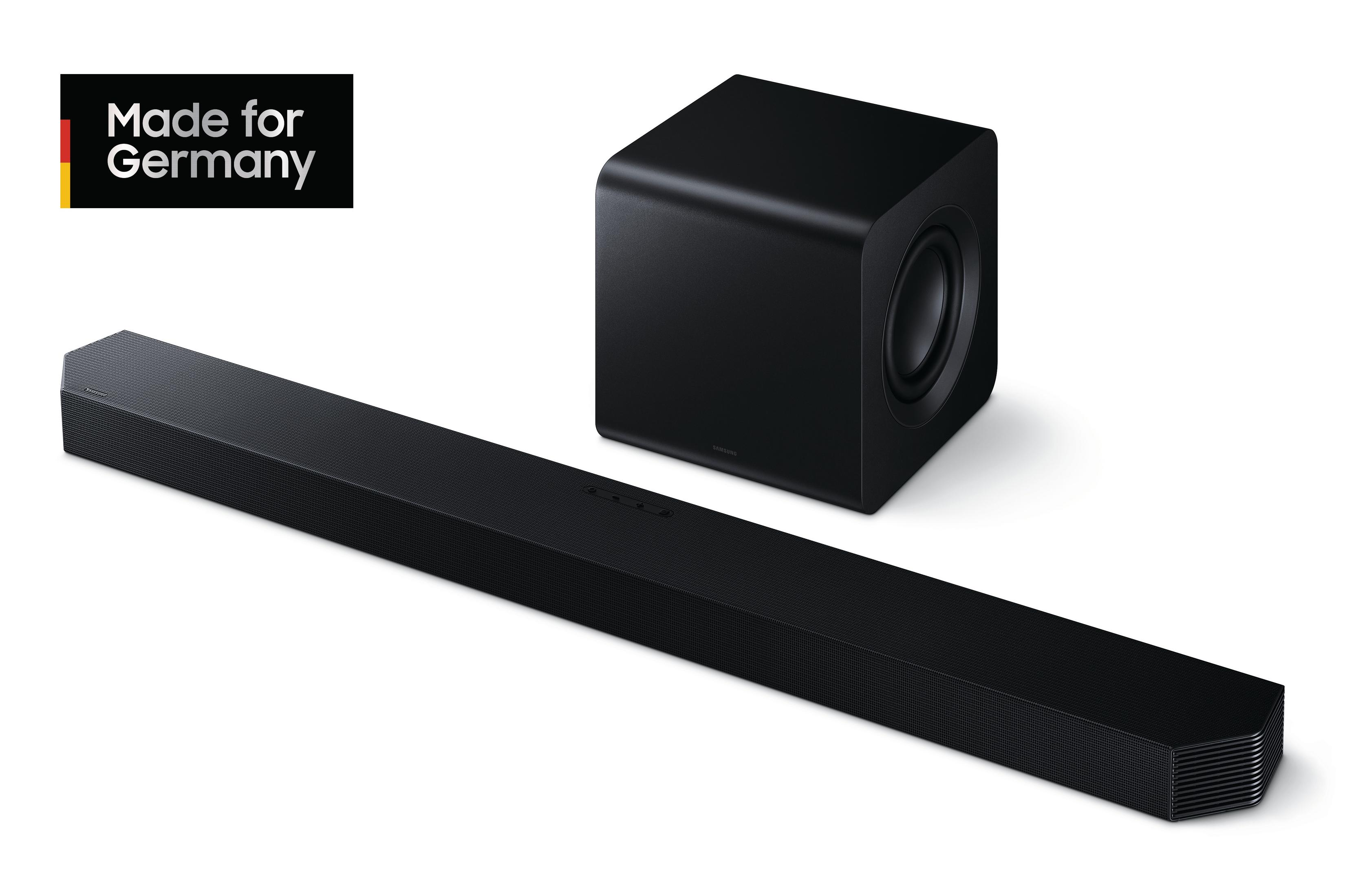 Eine schwarze Soundbar und ein Subwoofer. Die Soundbar ist lang und rechteckig. Der Subwoofer ist ein schwarzer Würfel.