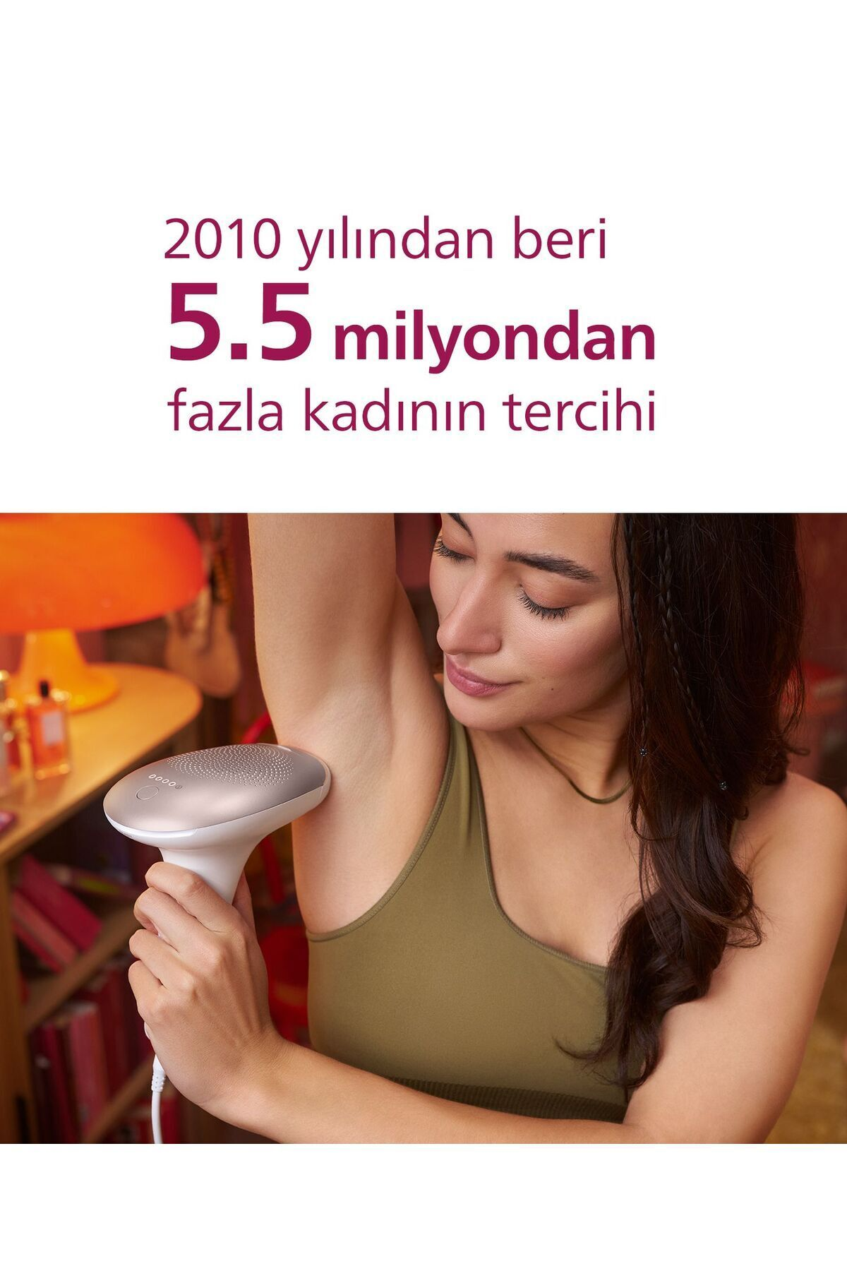 Bir kadın koltuk altındaki kılları almak için bir cihaz kullanıyor. Yukarıdaki metin şöyle diyor: '2010'dan beri 5,5 milyon kadının tercihi'.