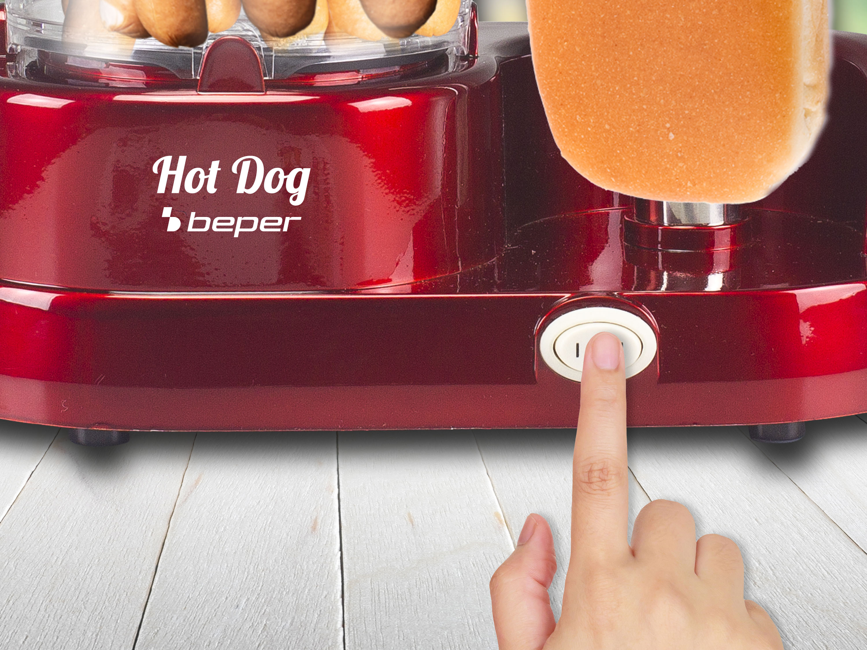 Una macchina per hot dog rossa con un panino e una mano che preme un pulsante.