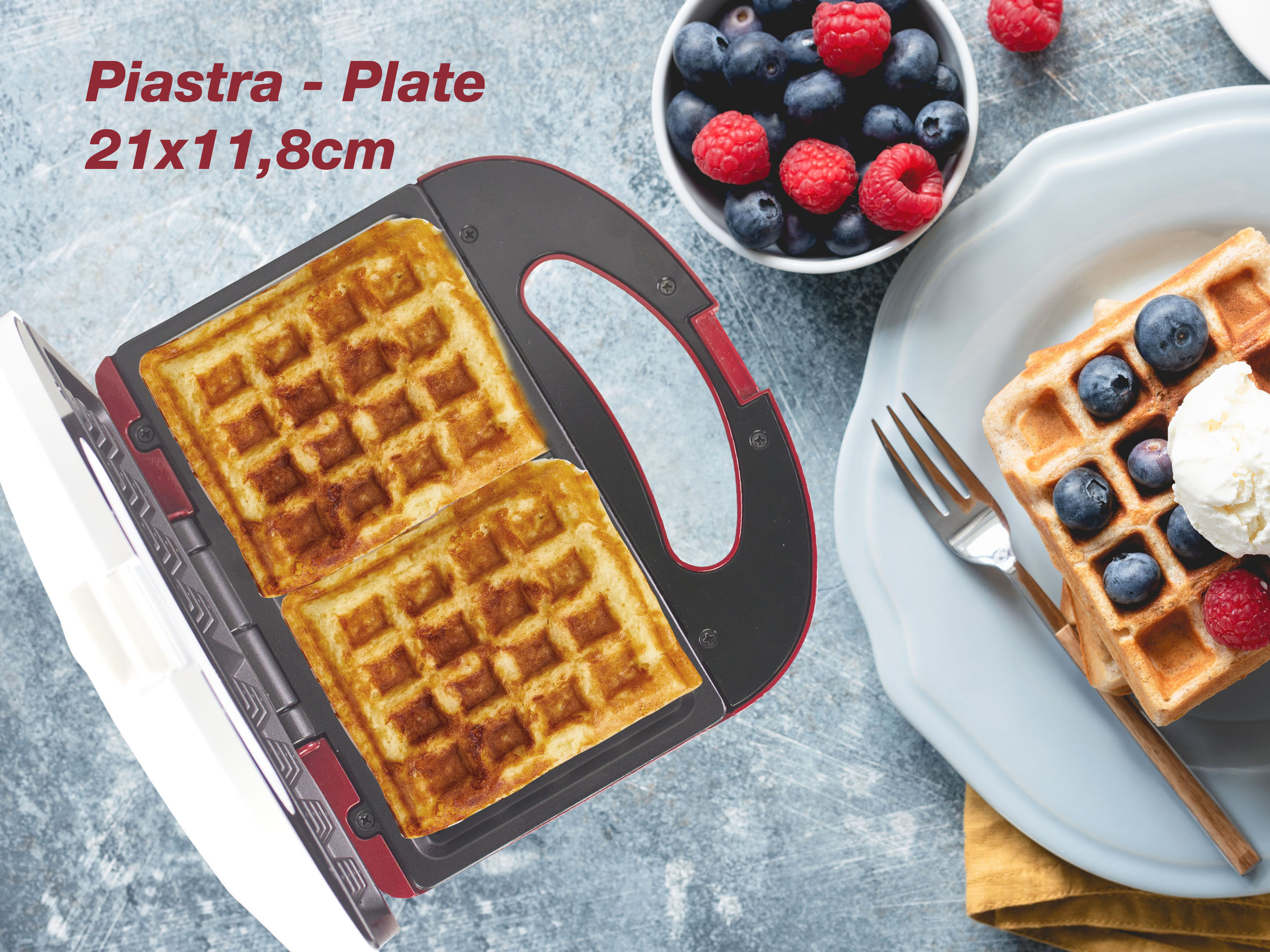 Una macchina per waffle con waffle, mirtilli e lamponi in un piatto.