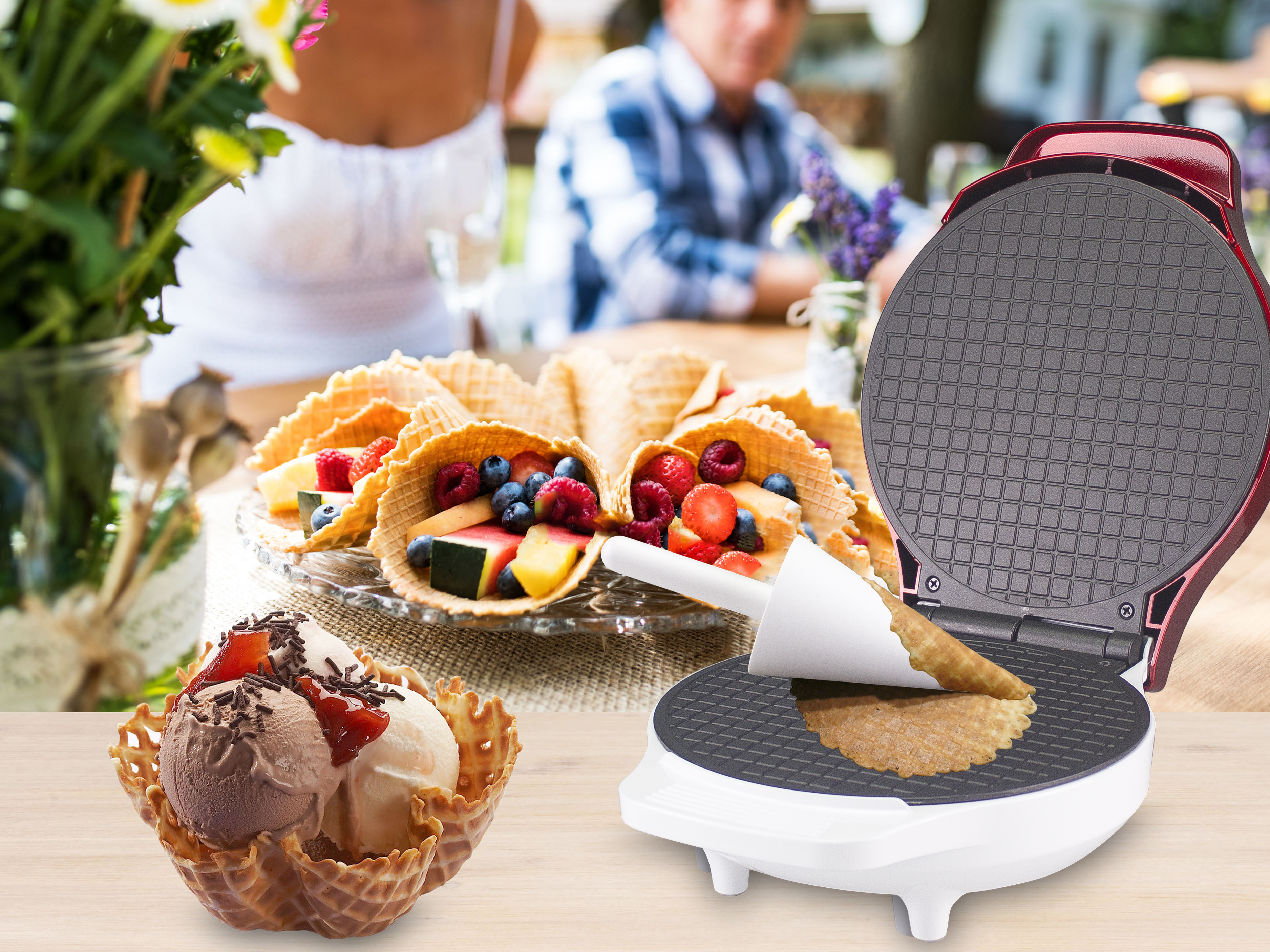 Macchina per waffle e coni waffle ripieni di frutta e gelato. Persone sullo sfondo.