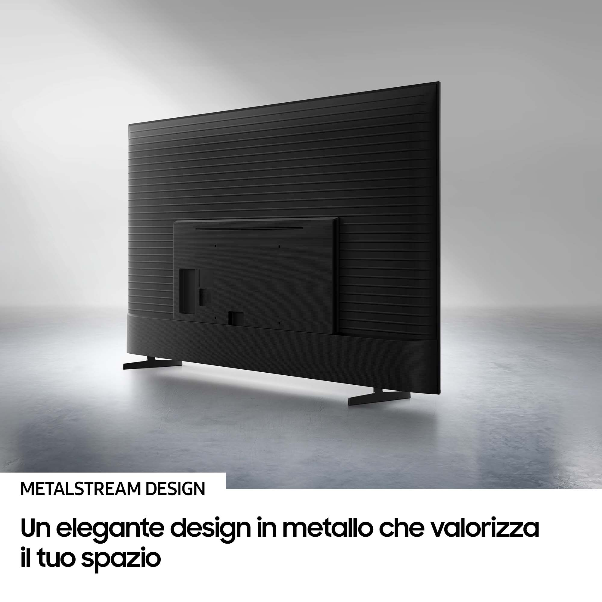 Vue arrière d'un téléviseur noir sur fond gris. Il a un design en métal et est posé sur deux pieds. Le mur a des lignes.