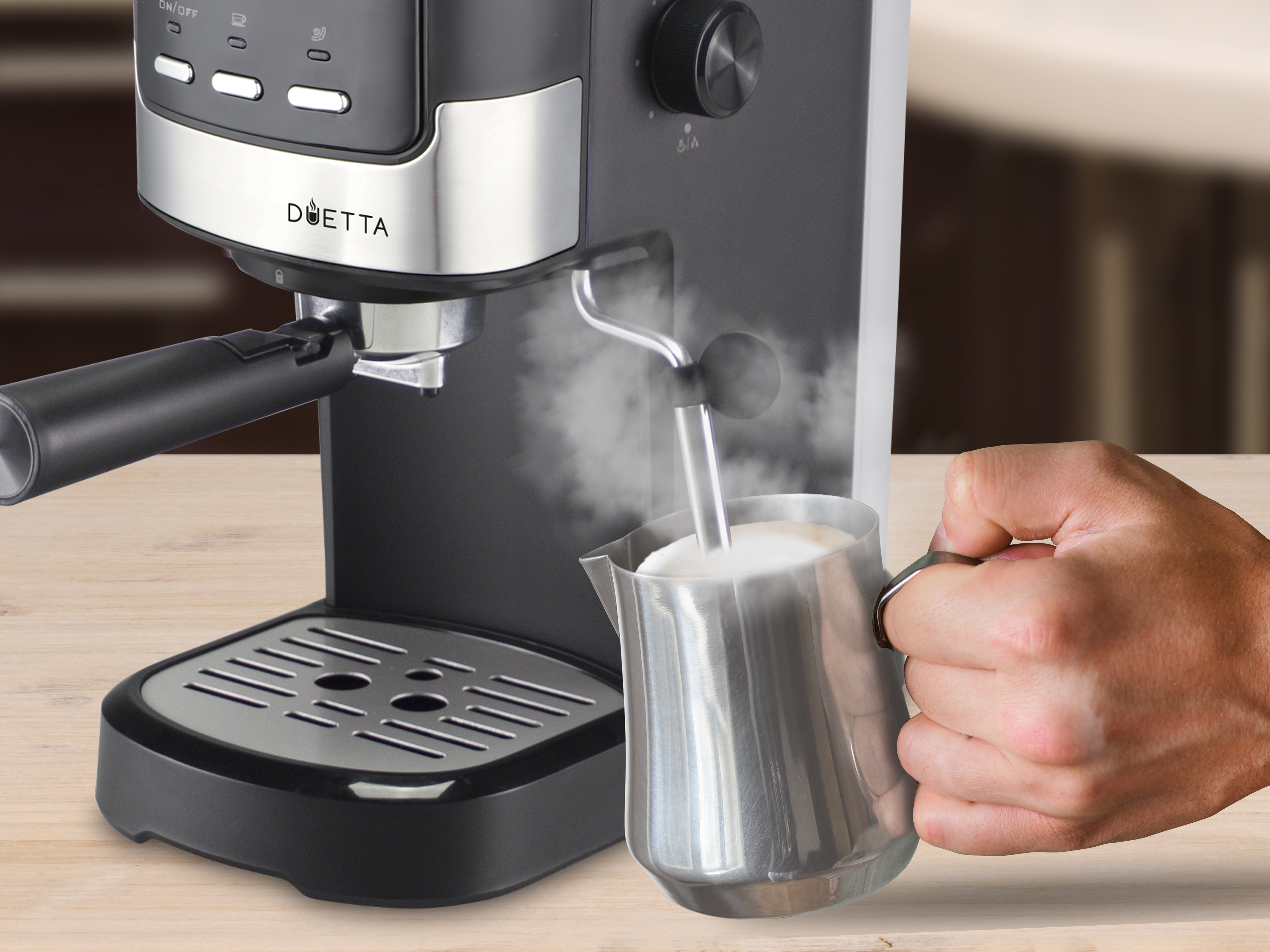 Una macchina per caffè espresso con una caraffa fumante. Una mano tiene la caraffa, vaporizzando il latte, creando una bevanda al caffè.