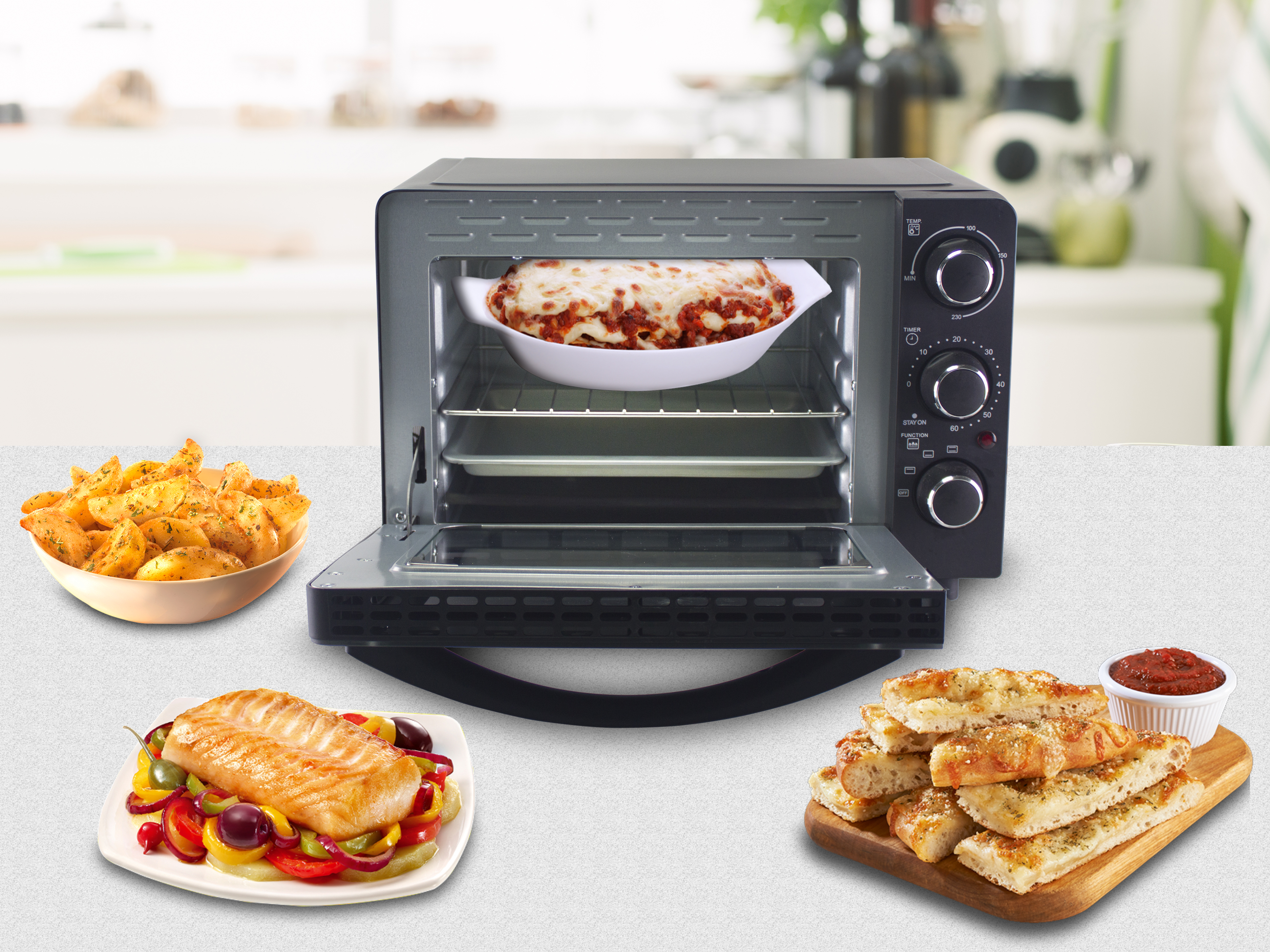 Un tostapane aperto con lasagne, pesce, pane e patatine fritte. Lo sfondo è un ambiente cucina.