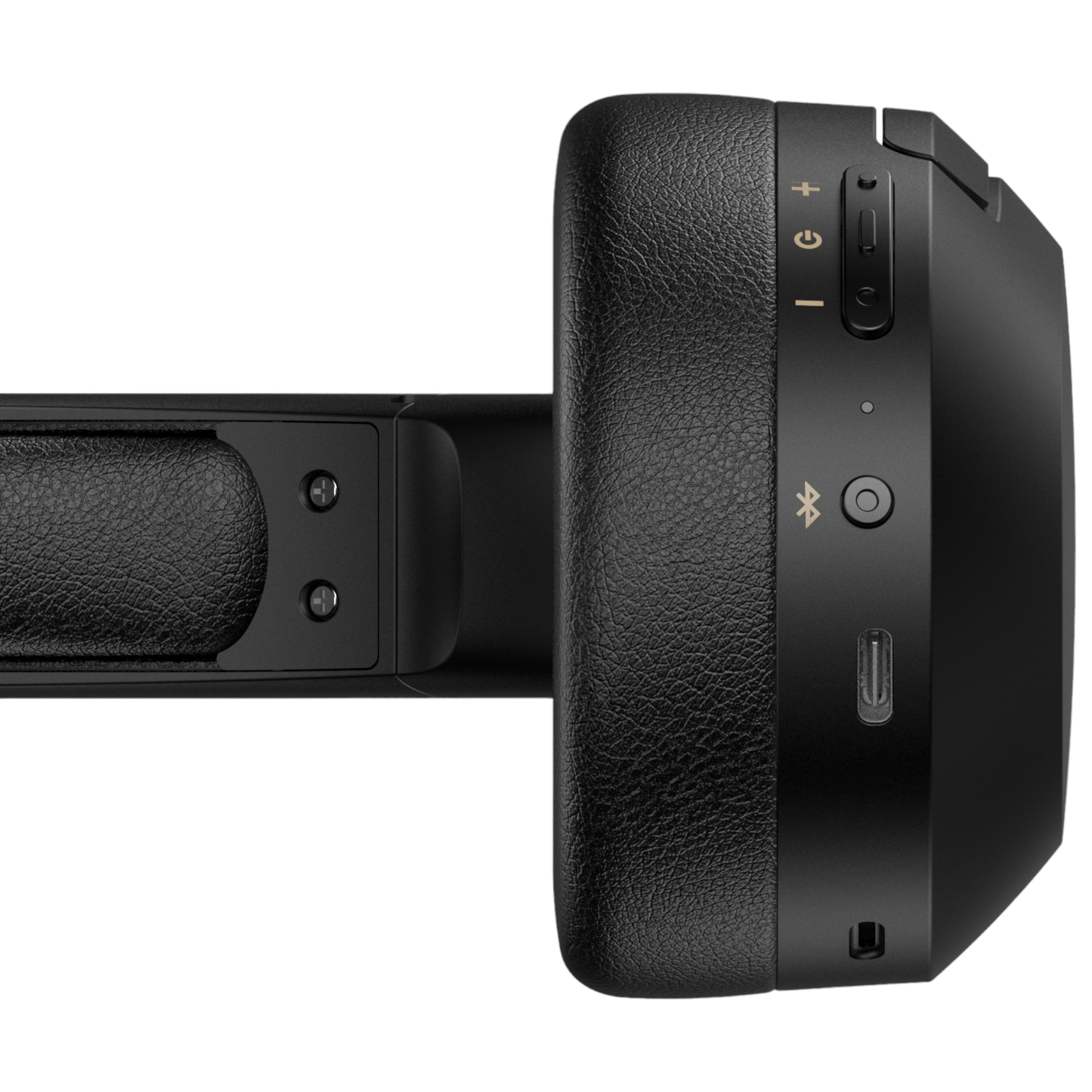 Czarne słuchawki bezprzewodowe, widok z boku. Zawierają przyciski zasilania, głośności i Bluetooth. Tekstura na nauszniku.