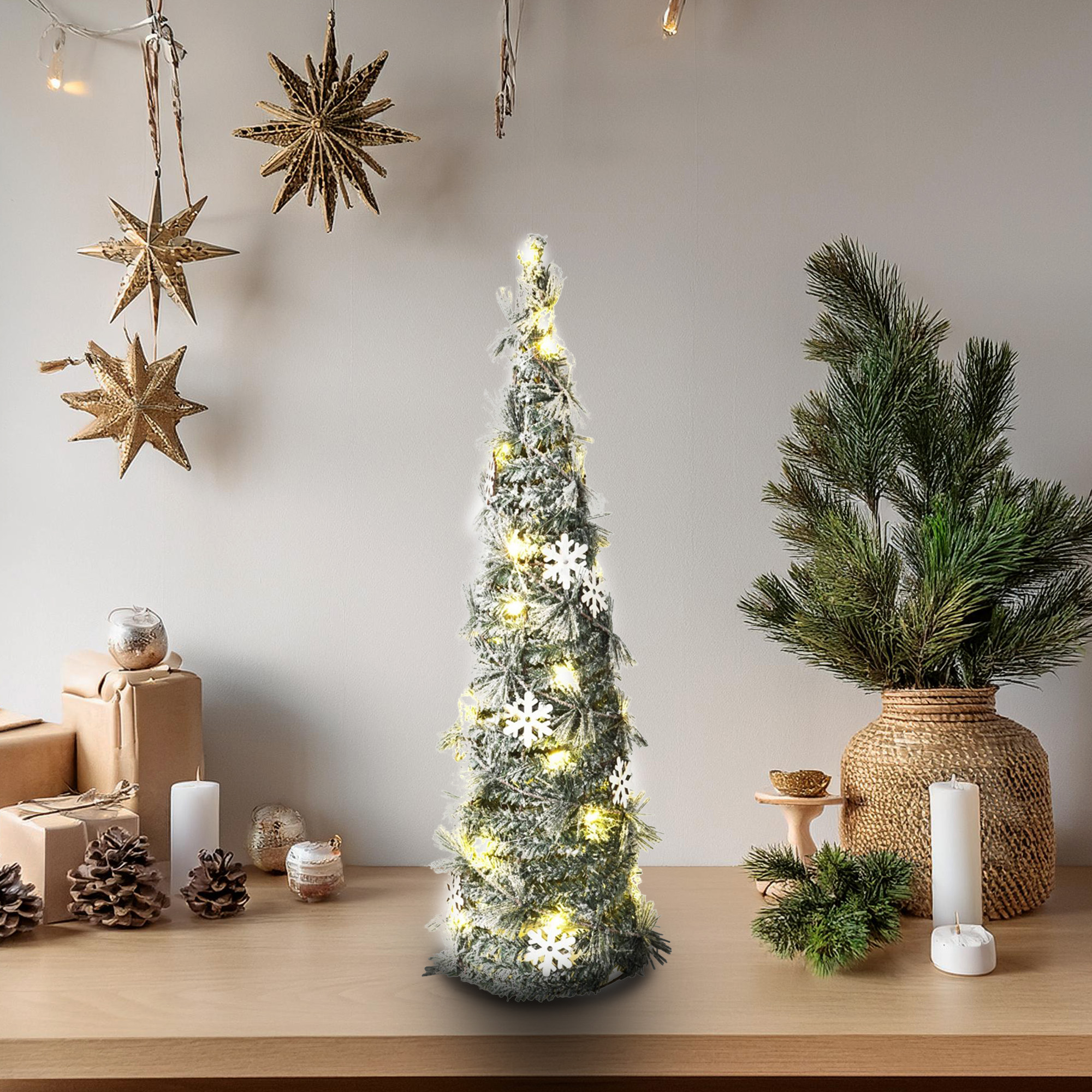 Un árbol de Navidad decorado con luces y copos de nieve, rodeado de regalos, piñas, estrellas y velas.