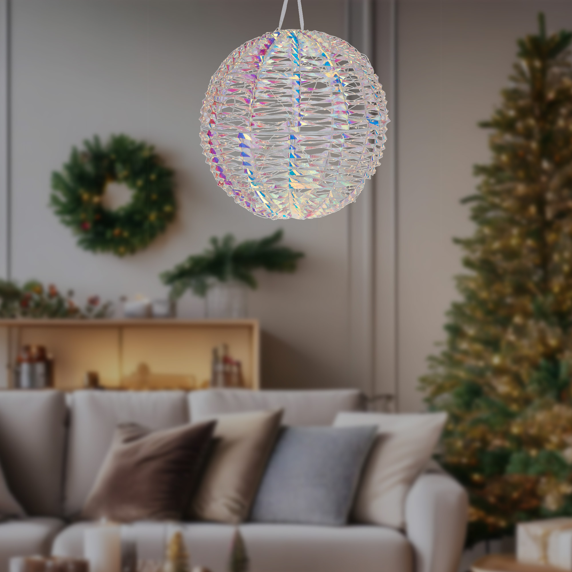 Un adorno esférico iridiscente colgante. Un árbol de Navidad y una corona están en el fondo borroso. Un sofá también.