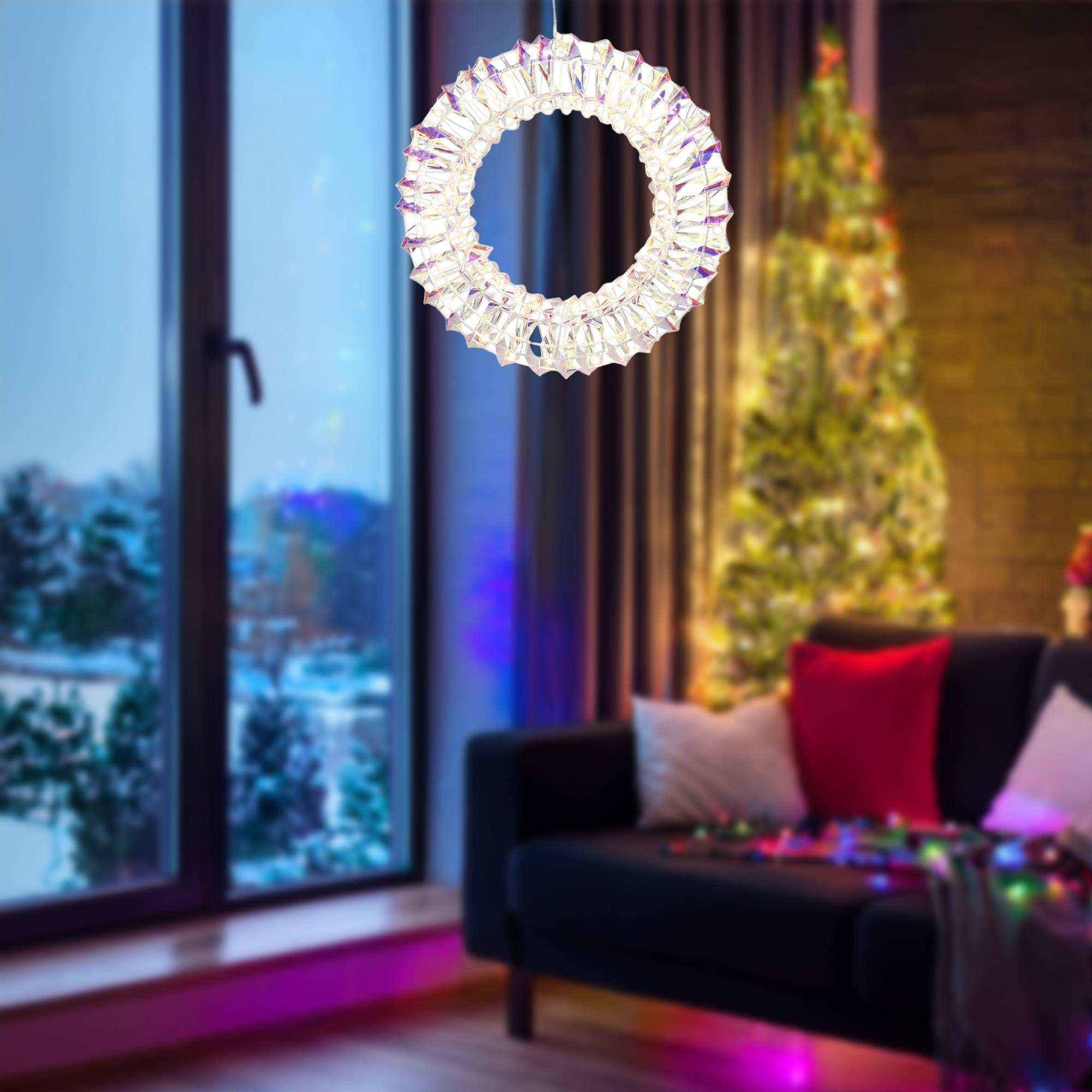 Una corona de cristal cuelga frente a una ventana. Un árbol de Navidad y un sofá son visibles al fondo.