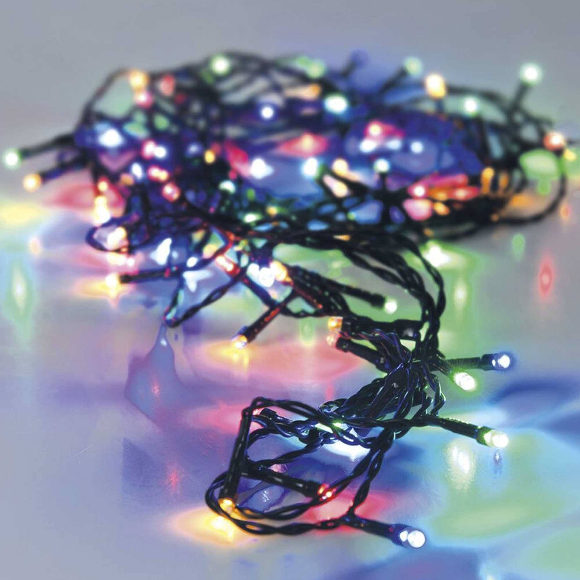 Cadena de luces navideñas multicolores sobre fondo blanco. Las luces son de varios colores.