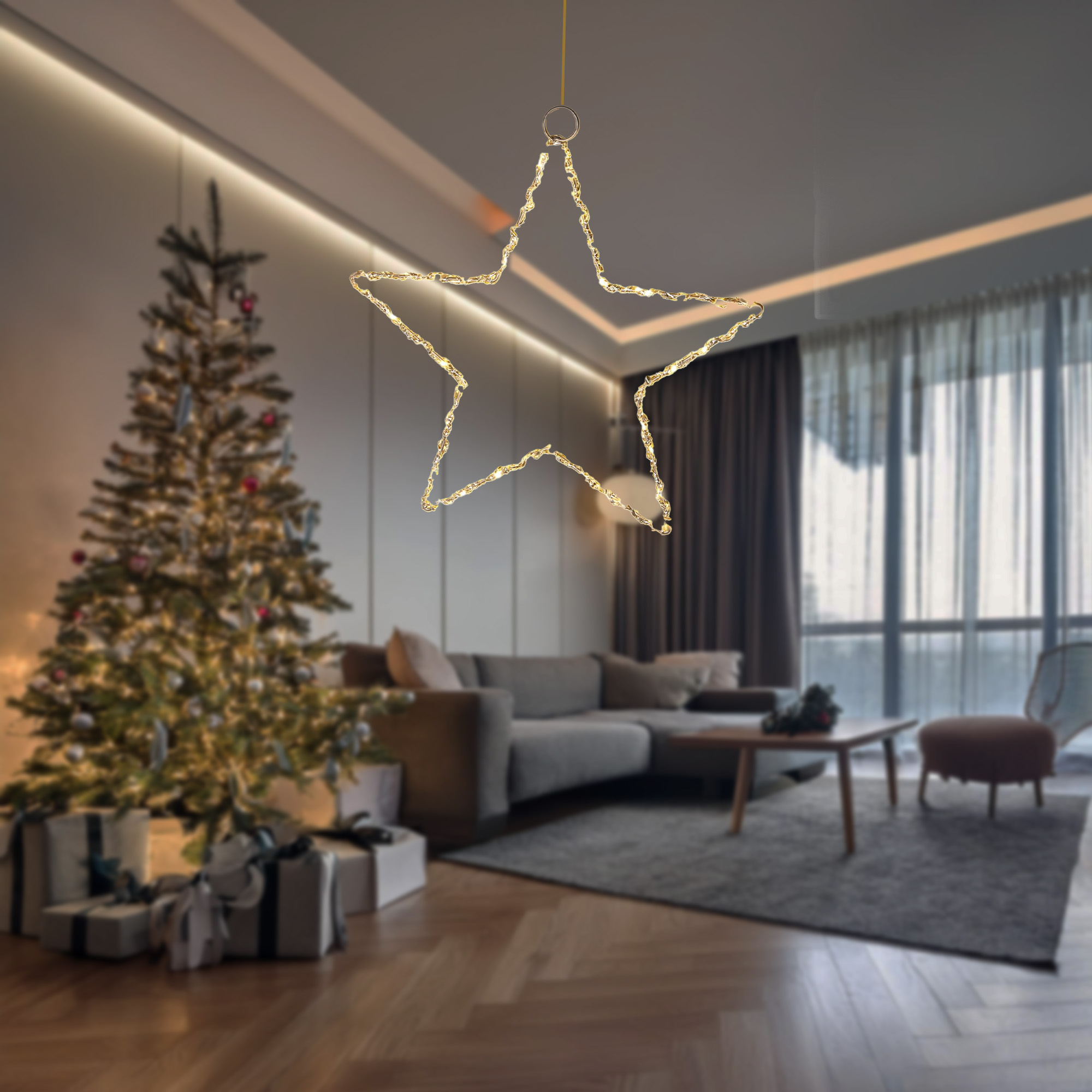 Una estrella dorada iluminada cuelga en una sala de estar. Un árbol y regalos están en el fondo borroso.