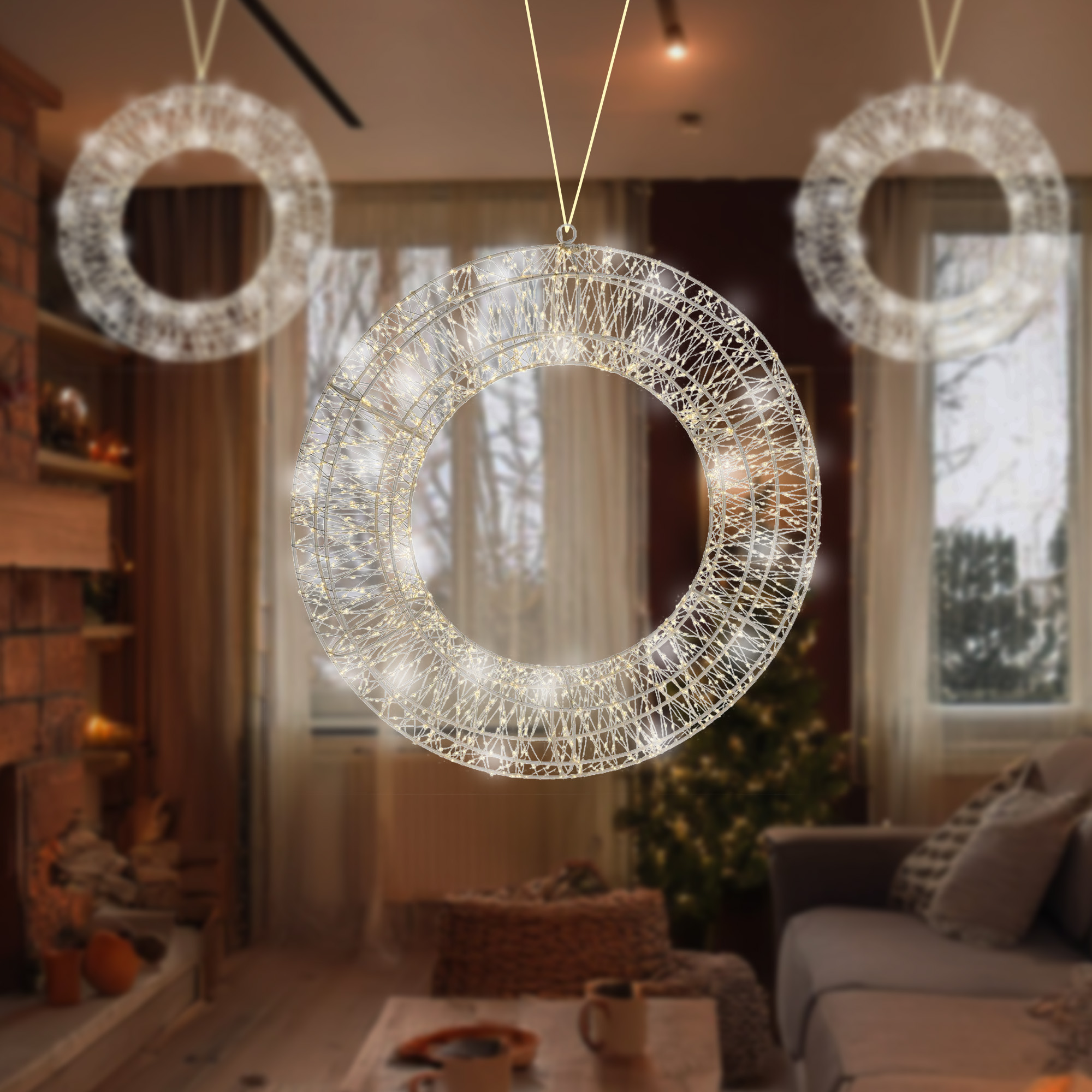 Tres decoraciones circulares iluminadas colgando en una habitación. Un salón con chimenea y un árbol de Navidad al fondo.