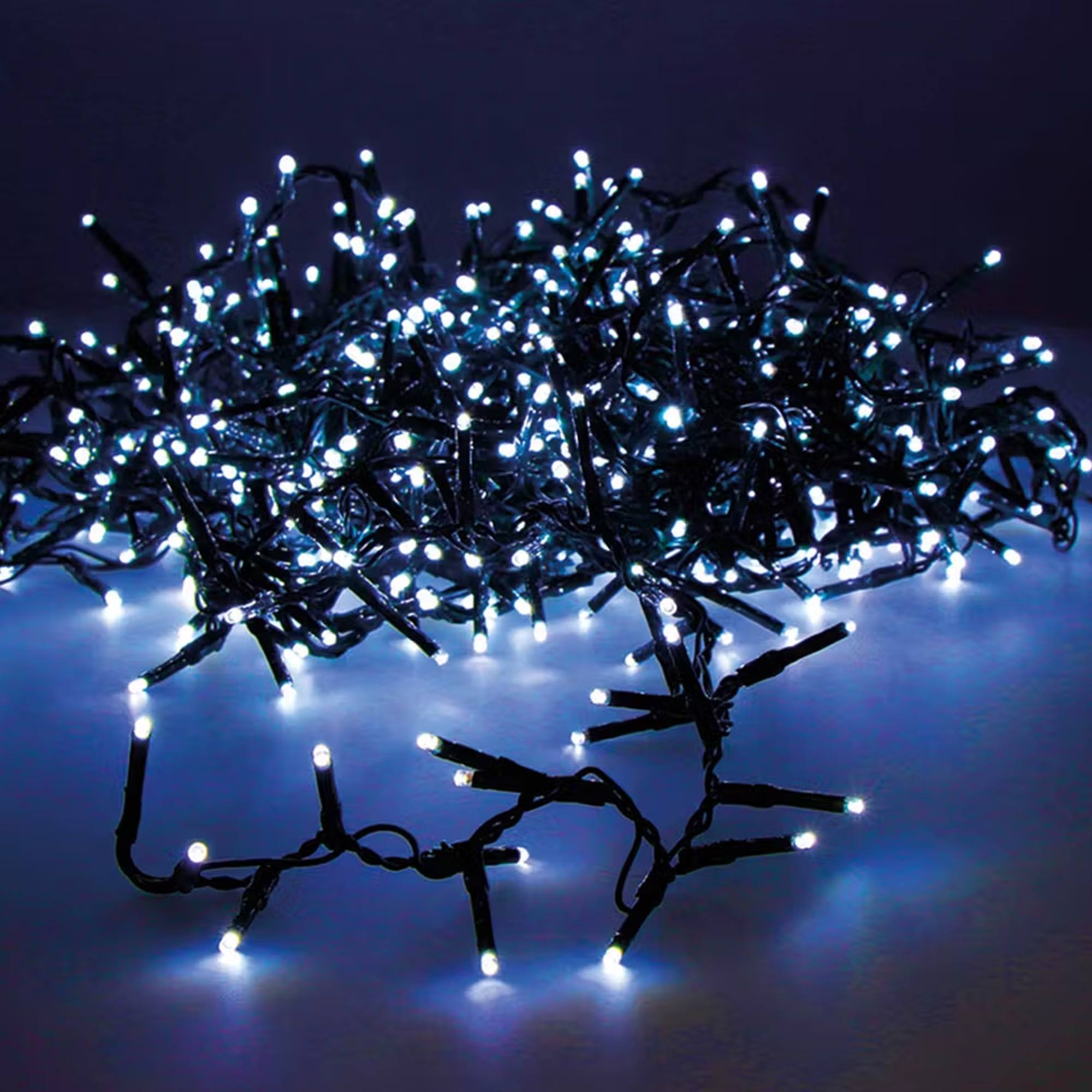 Un grupo de luces LED blancas en un fondo oscuro. Algunos hilos están en primer plano.