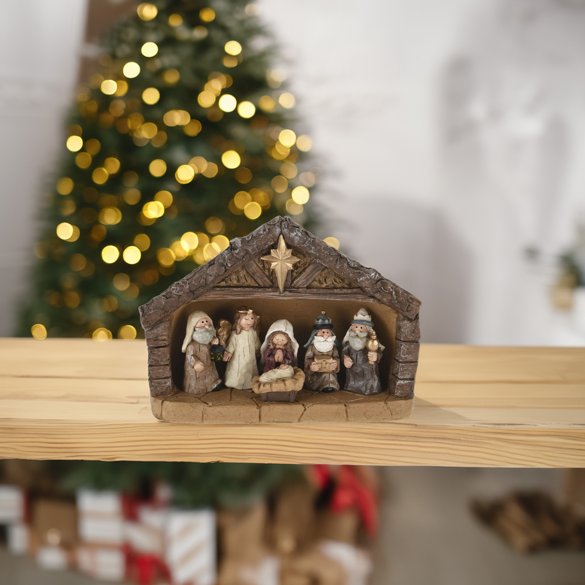 Un pesebre con figuras sobre una repisa de madera. Al fondo, un árbol de Navidad con luces doradas bokeh.