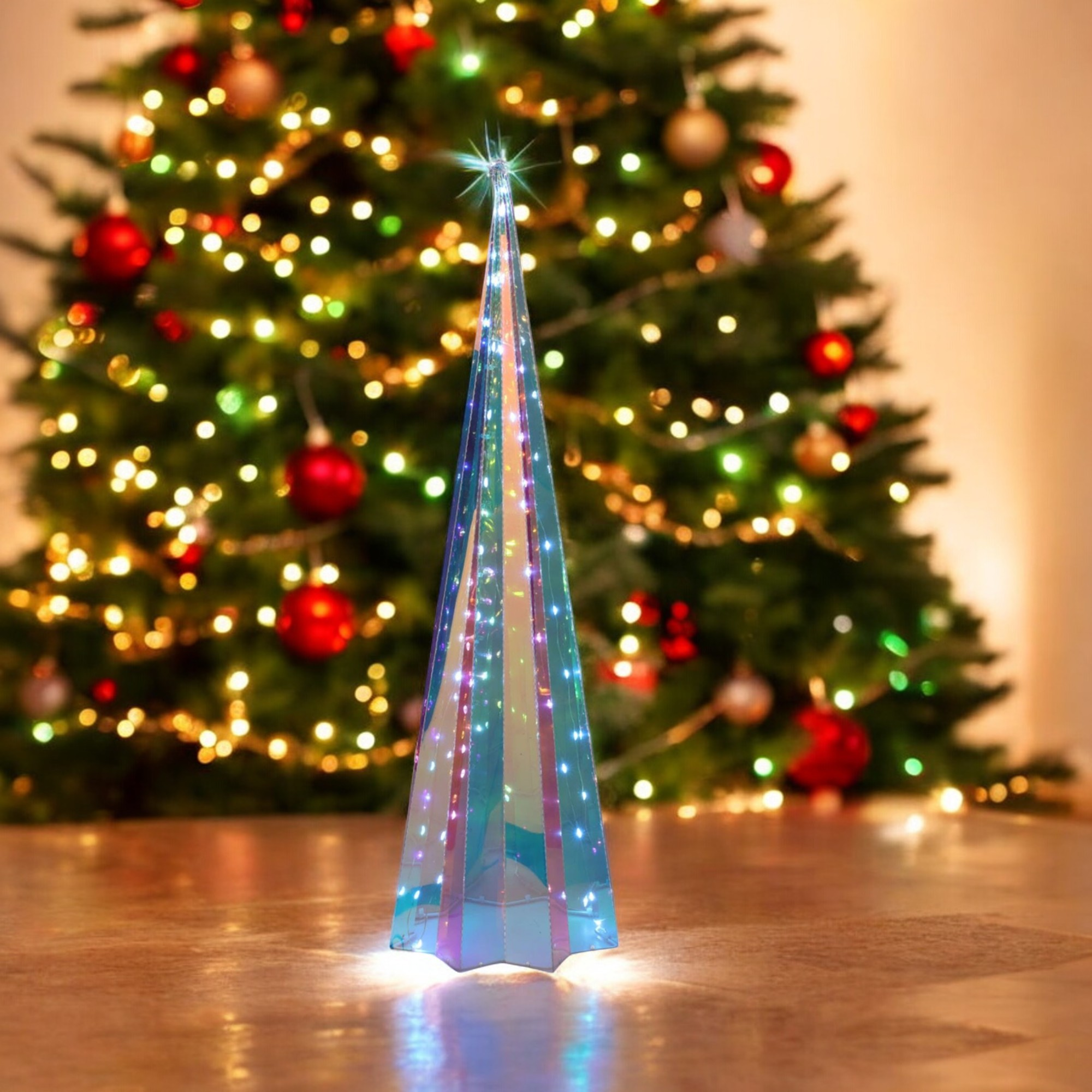 Un árbol de Navidad decorativo azul brillante se encuentra en un suelo de madera, con un árbol de Navidad decorado en el fondo.