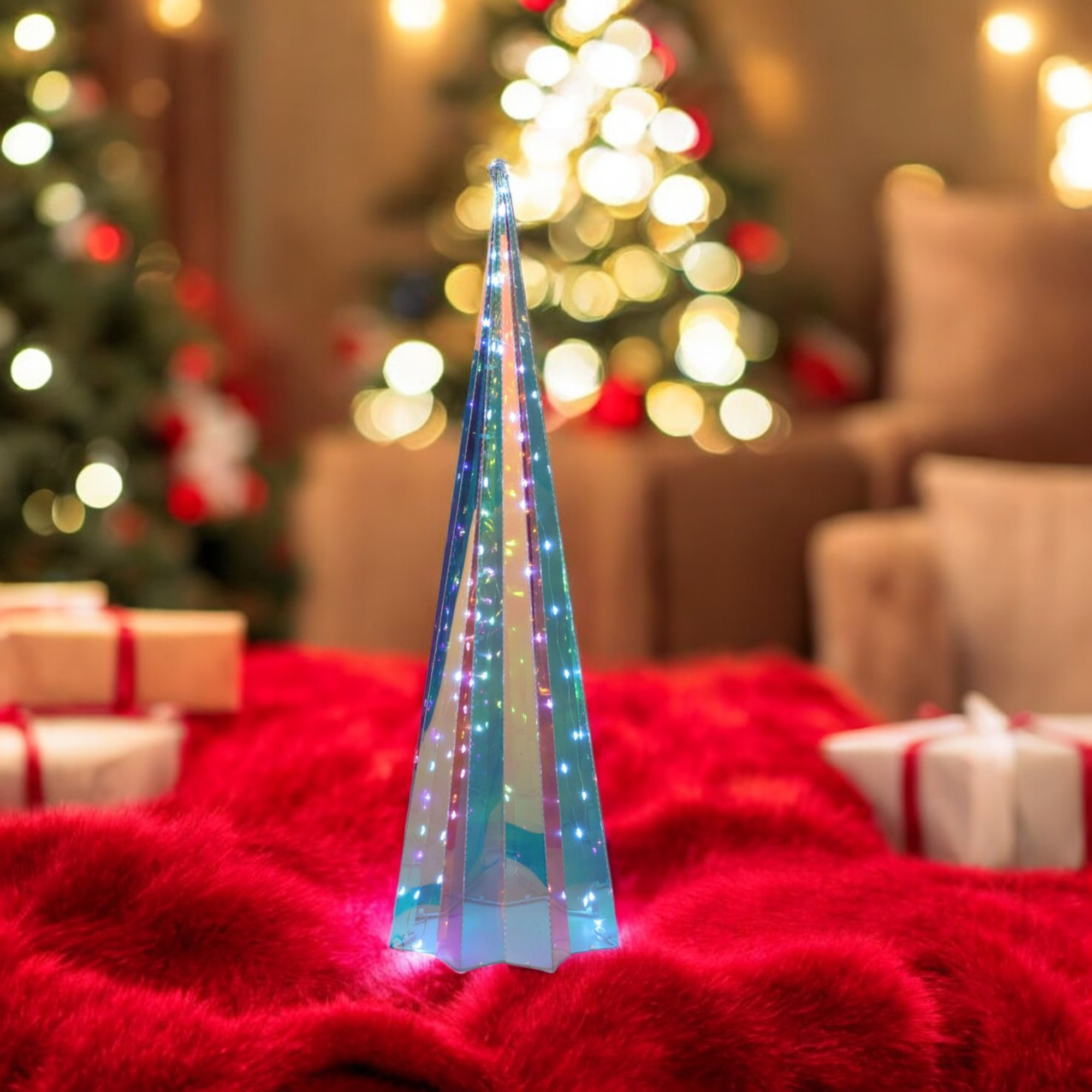 Un árbol de Navidad decorativo de vidrio está sobre una alfombra de piel roja. Otros árboles y regalos están en el fondo borroso.