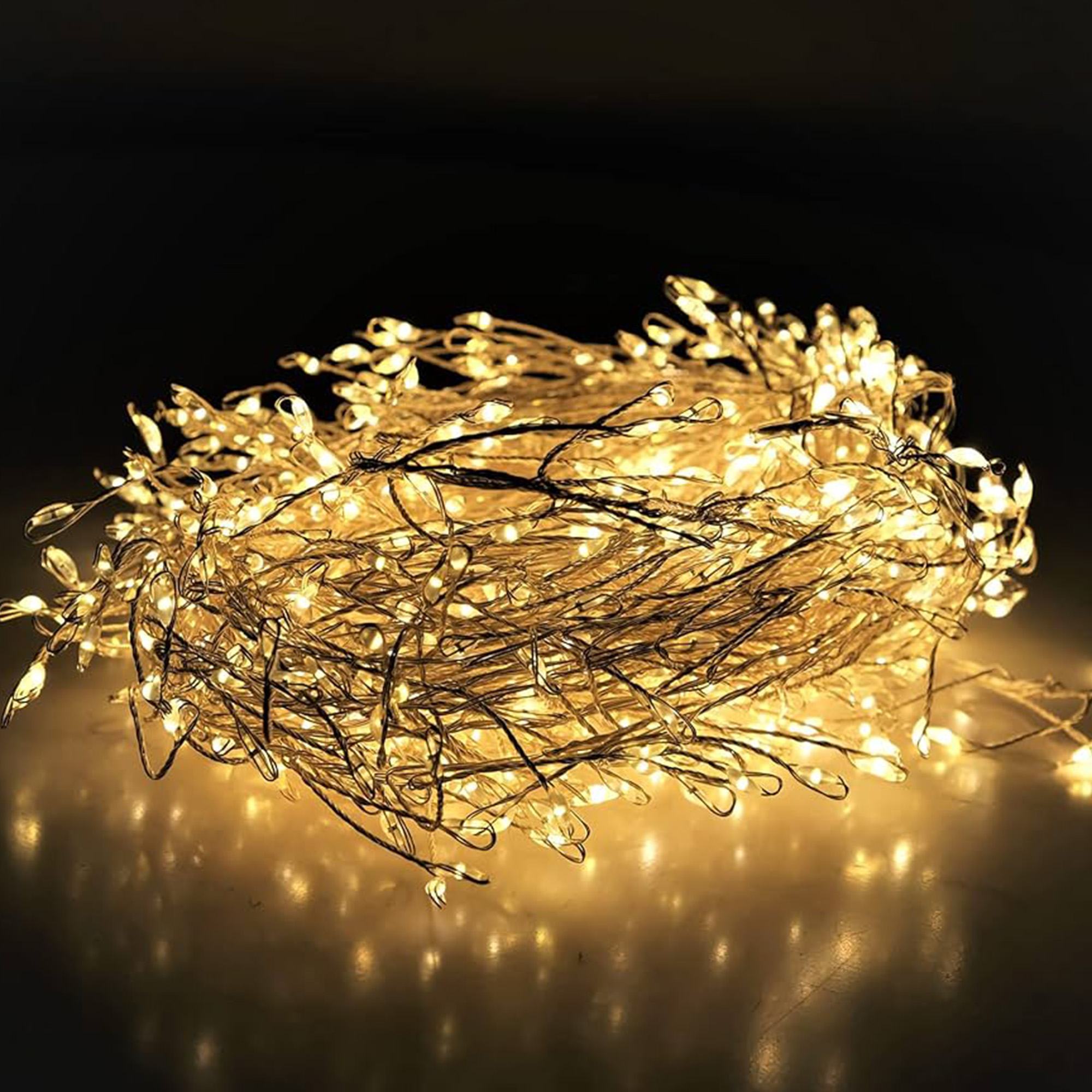 Un haz de luces de hadas brillantes, con pequeñas bombillas en cables delgados. La escena es contra un fondo oscuro.