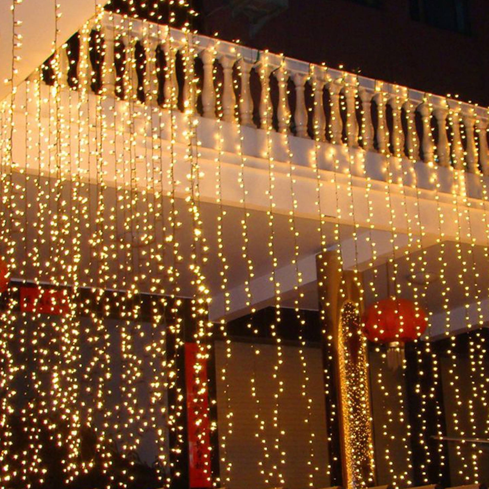 Balcón con hileras de luces blancas cálidas. Una linterna roja cuelga al fondo. Escena decorativa y festiva.