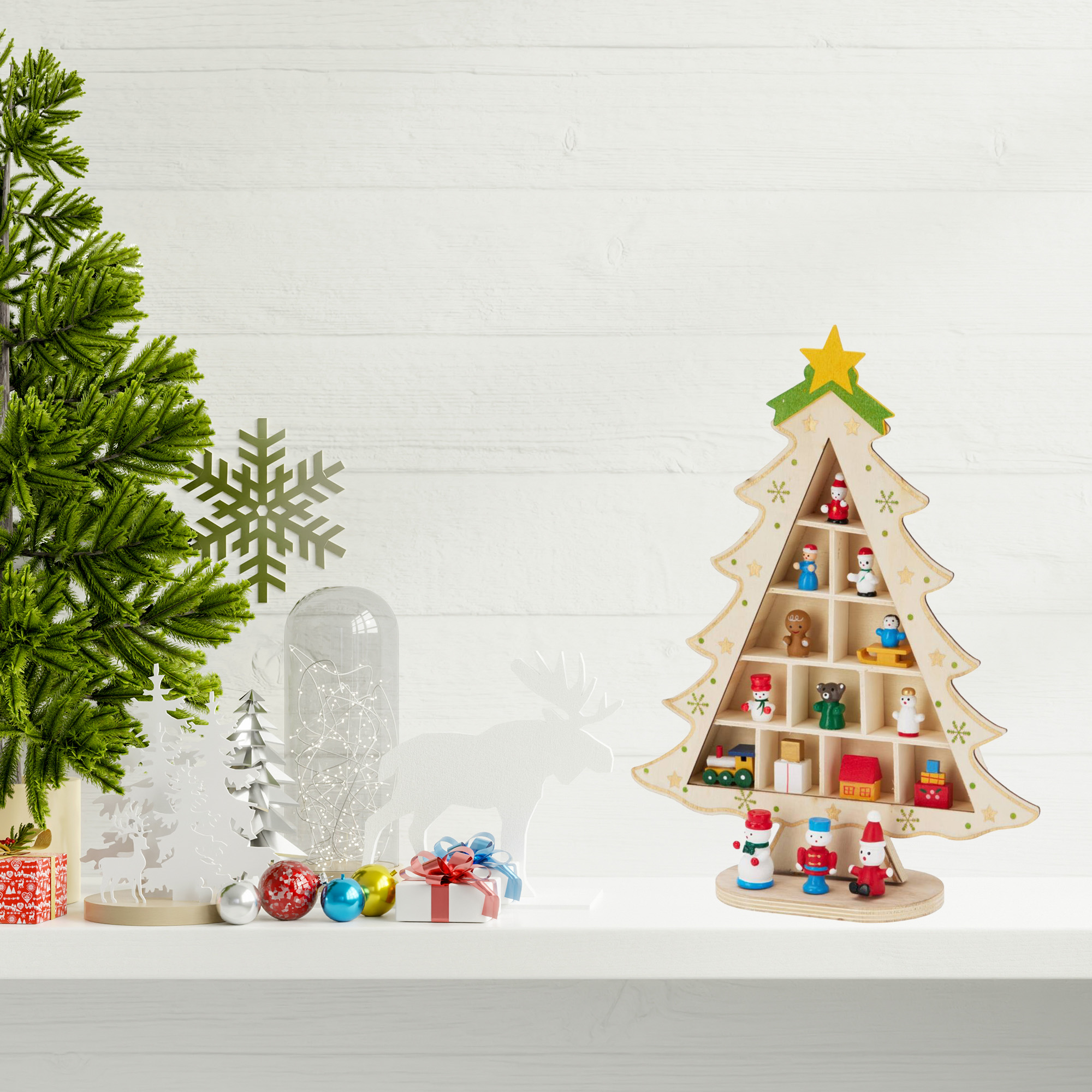 Una escena navideña con un estante en forma de árbol lleno de adornos y un árbol de Navidad verde sobre una superficie blanca.