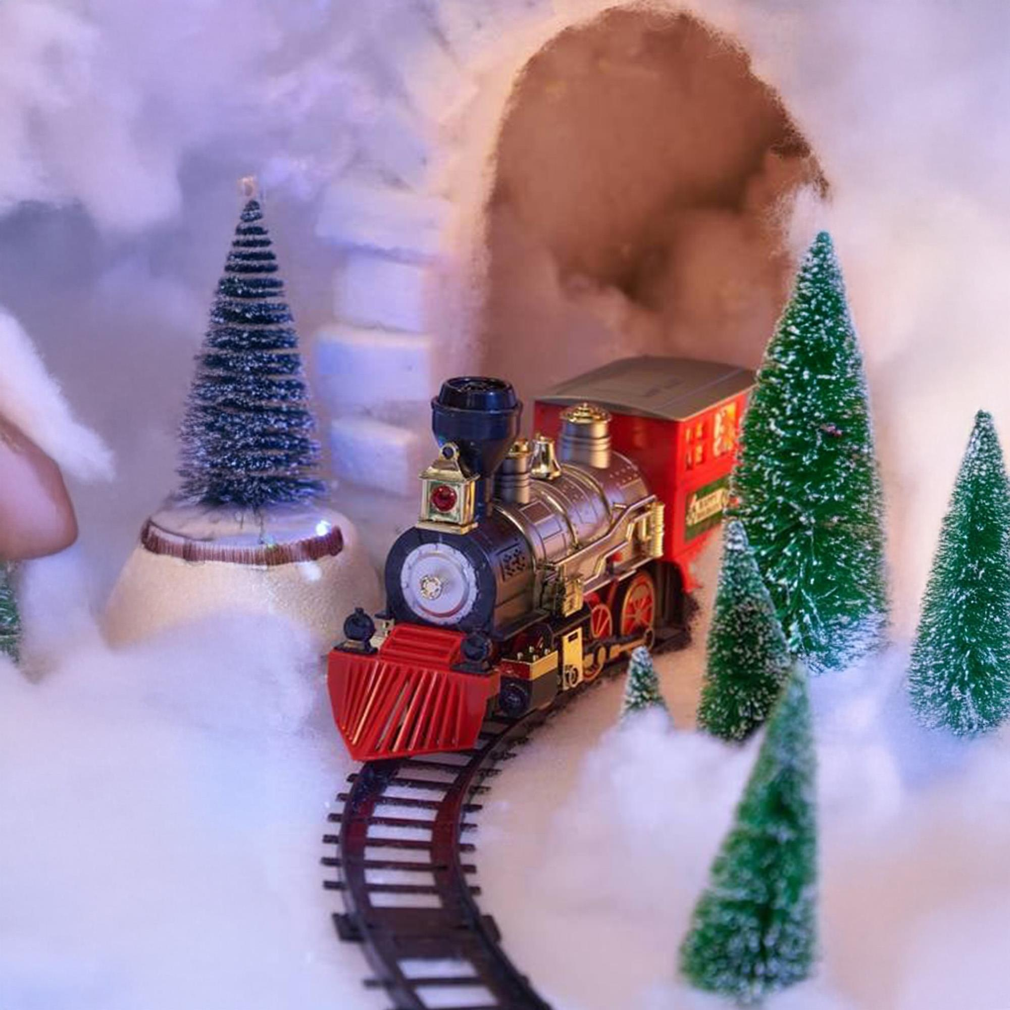 Un tren de juguete viaja por una escena nevada con árboles de Navidad. El tren tiene un frente rojo y un vagón rojo.