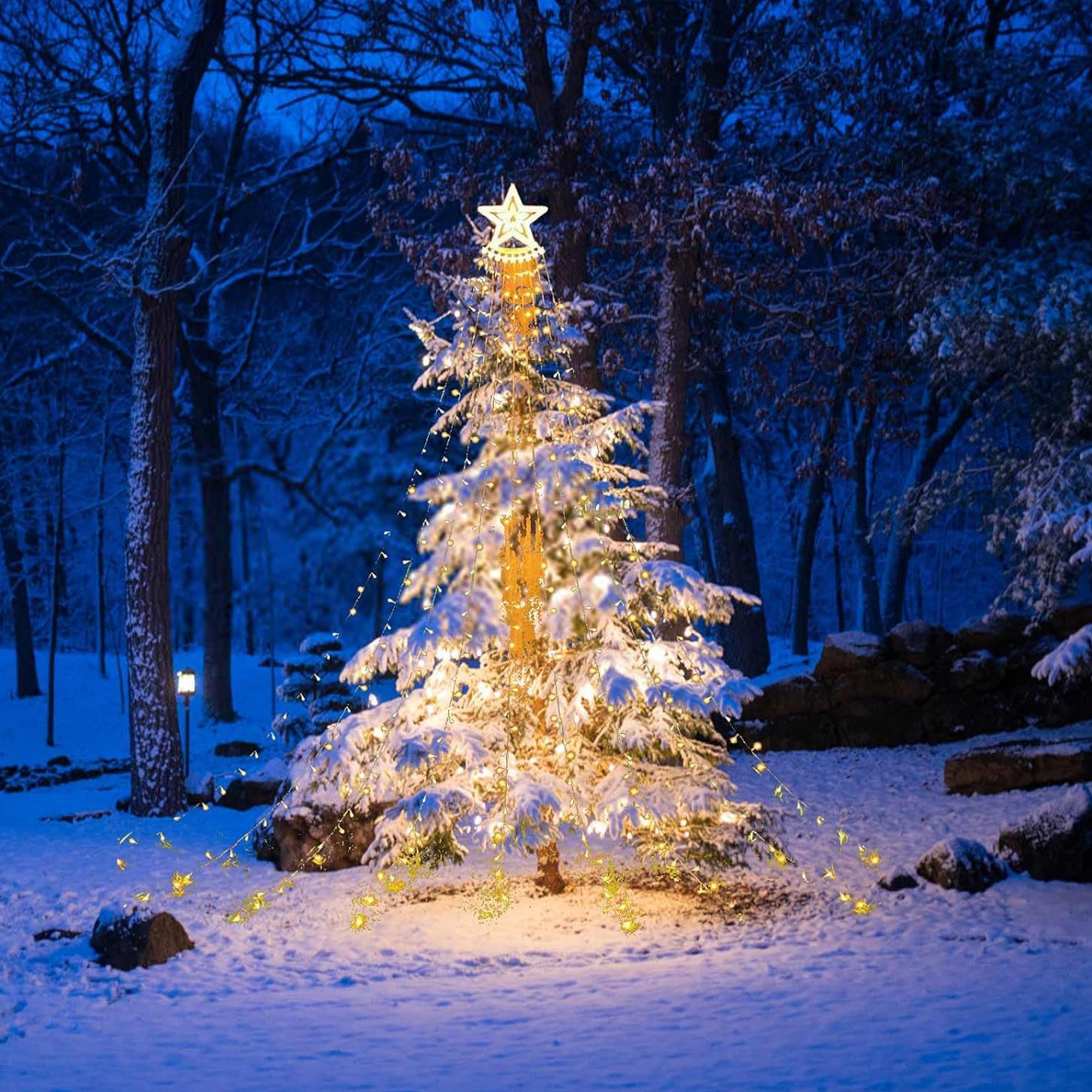 Un árbol de Navidad cubierto de nieve con luces cálidas y una estrella, en un bosque nevado de noche.