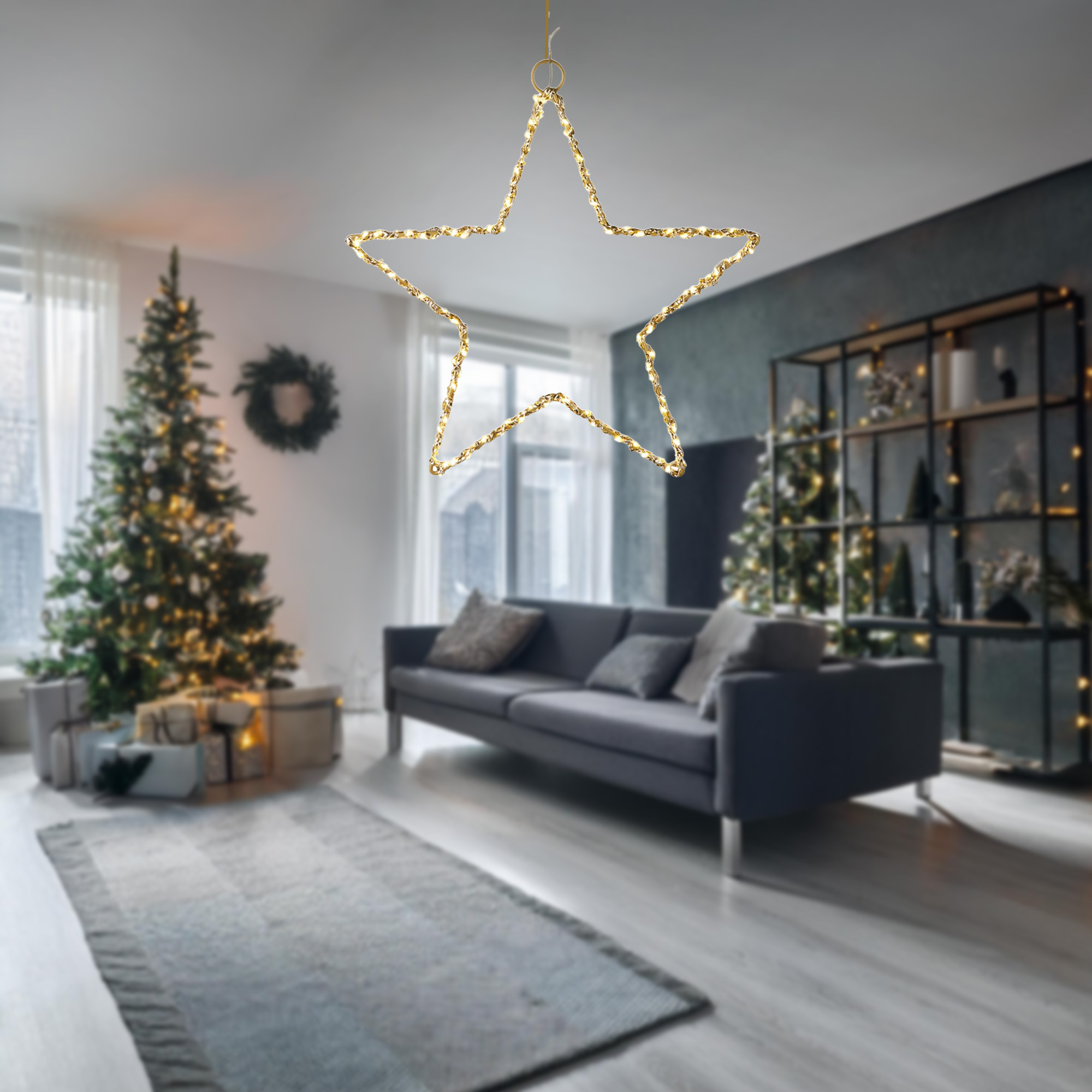 Una estrella decorativa iluminada cuelga en una habitación con un árbol de Navidad, sofá y regalos. Luces cálidas crean ambiente festivo.