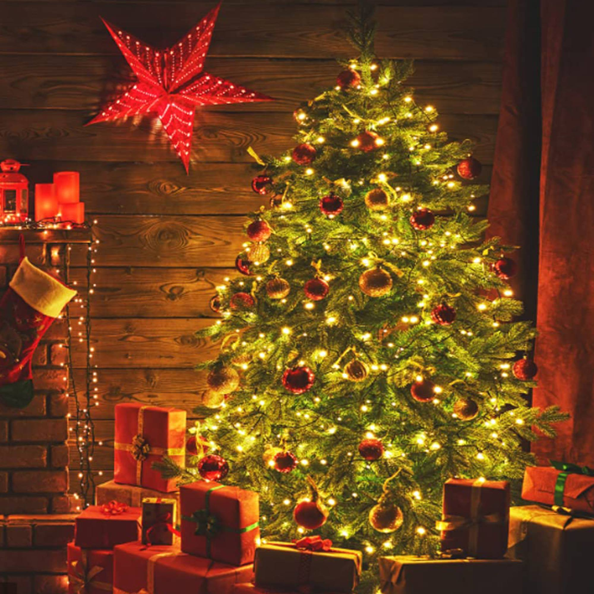Un árbol de Navidad decorado con luces y adornos. Estrella roja, regalos, chimenea y velas. Escena festiva.