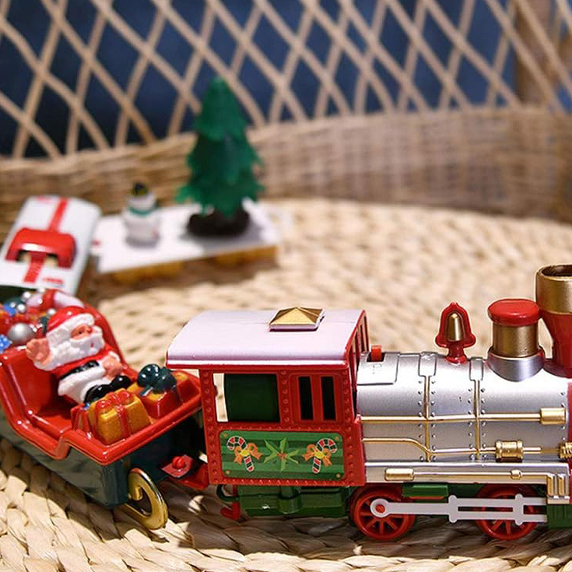 Un tren de juguete con un vagón de Santa y adornos navideños sobre una estera tejida, con fondo borroso.