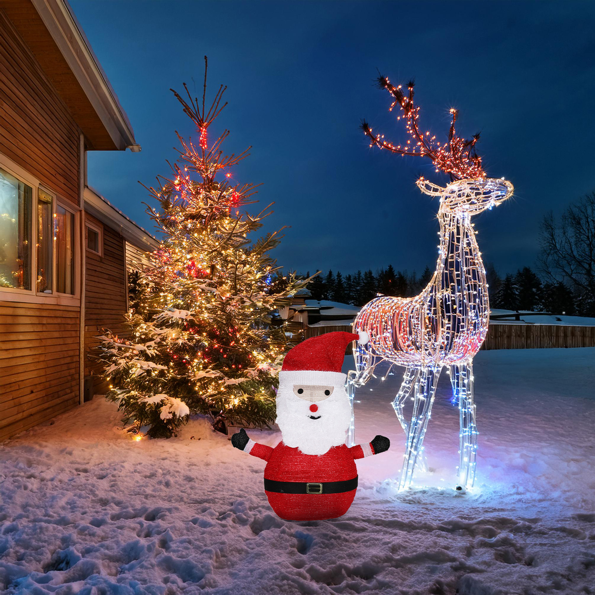 Un árbol de Navidad iluminado, una estatua de Papá Noel y un reno iluminado están en la nieve. Una casa está en el fondo contra un cielo azul oscuro.