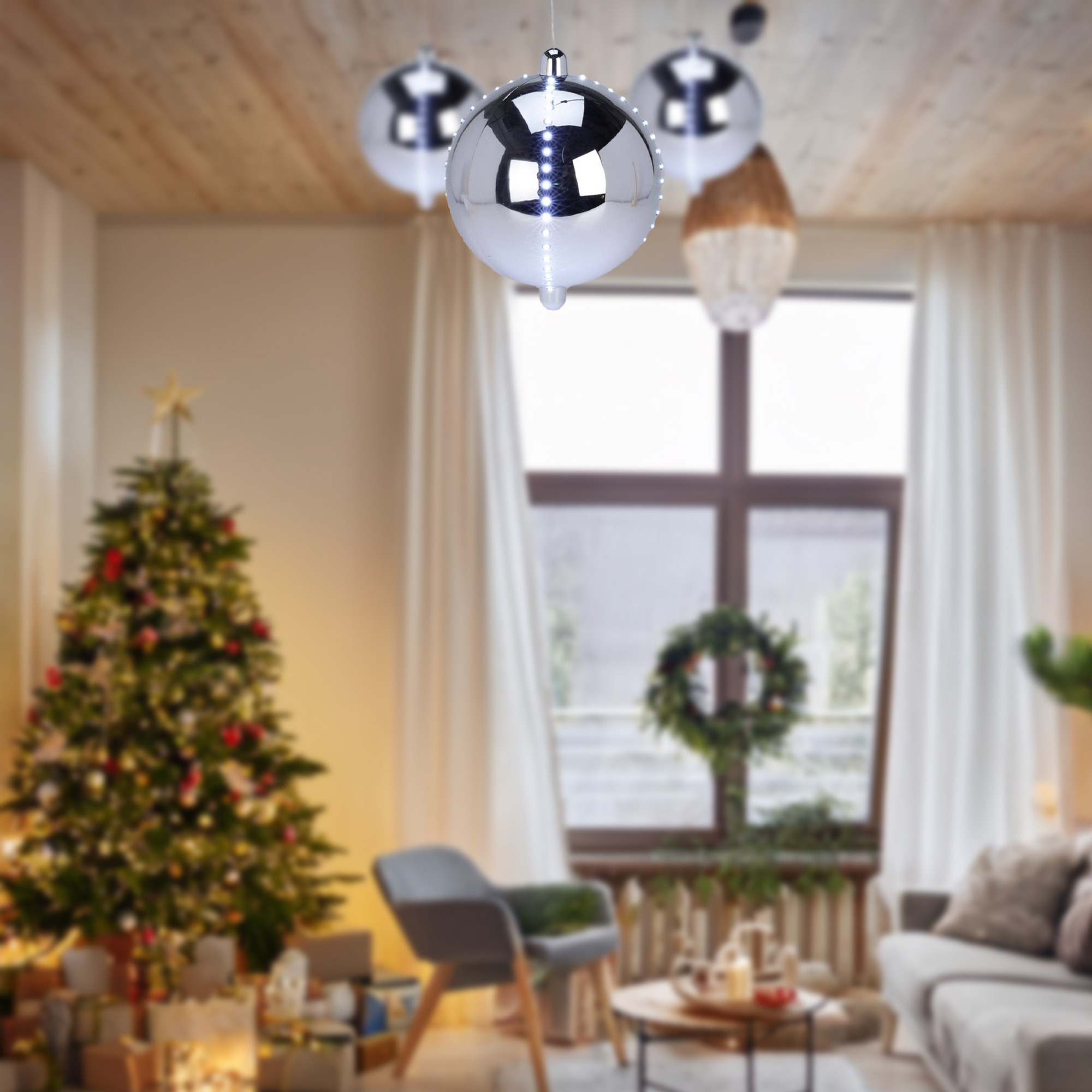 Un árbol de Navidad decorado en una sala de estar con adornos plateados colgantes. Regalos debajo del árbol.