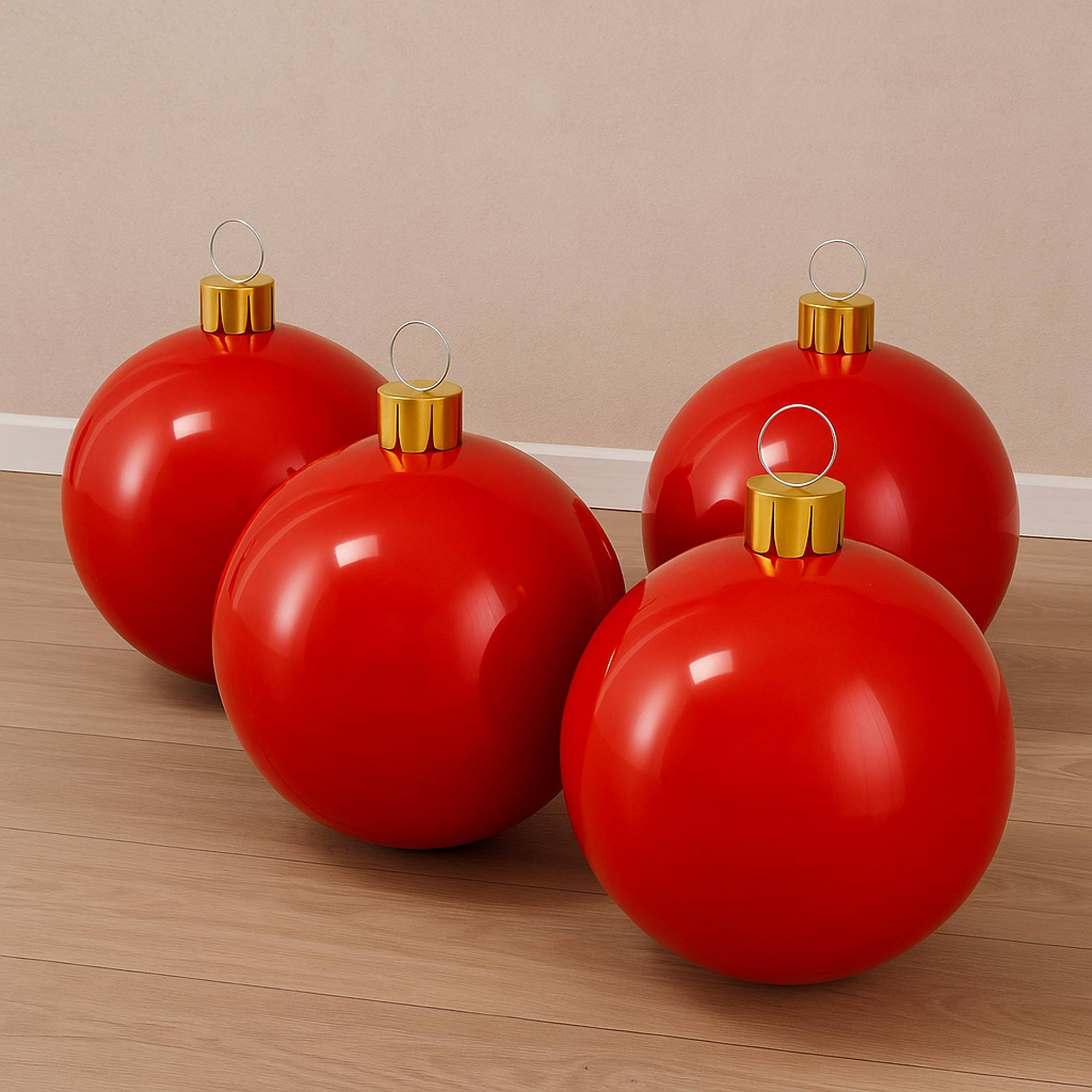 Cuatro grandes adornos navideños rojos con tapas doradas y lazos plateados están en un piso de madera contra una pared beige.