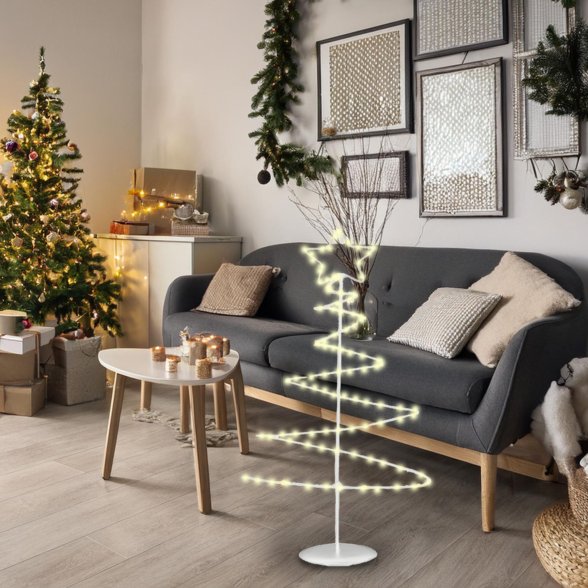 Un salón decorado para Navidad con un árbol iluminado, un sofá y un árbol de luces en espiral. Hay regalos y velas.