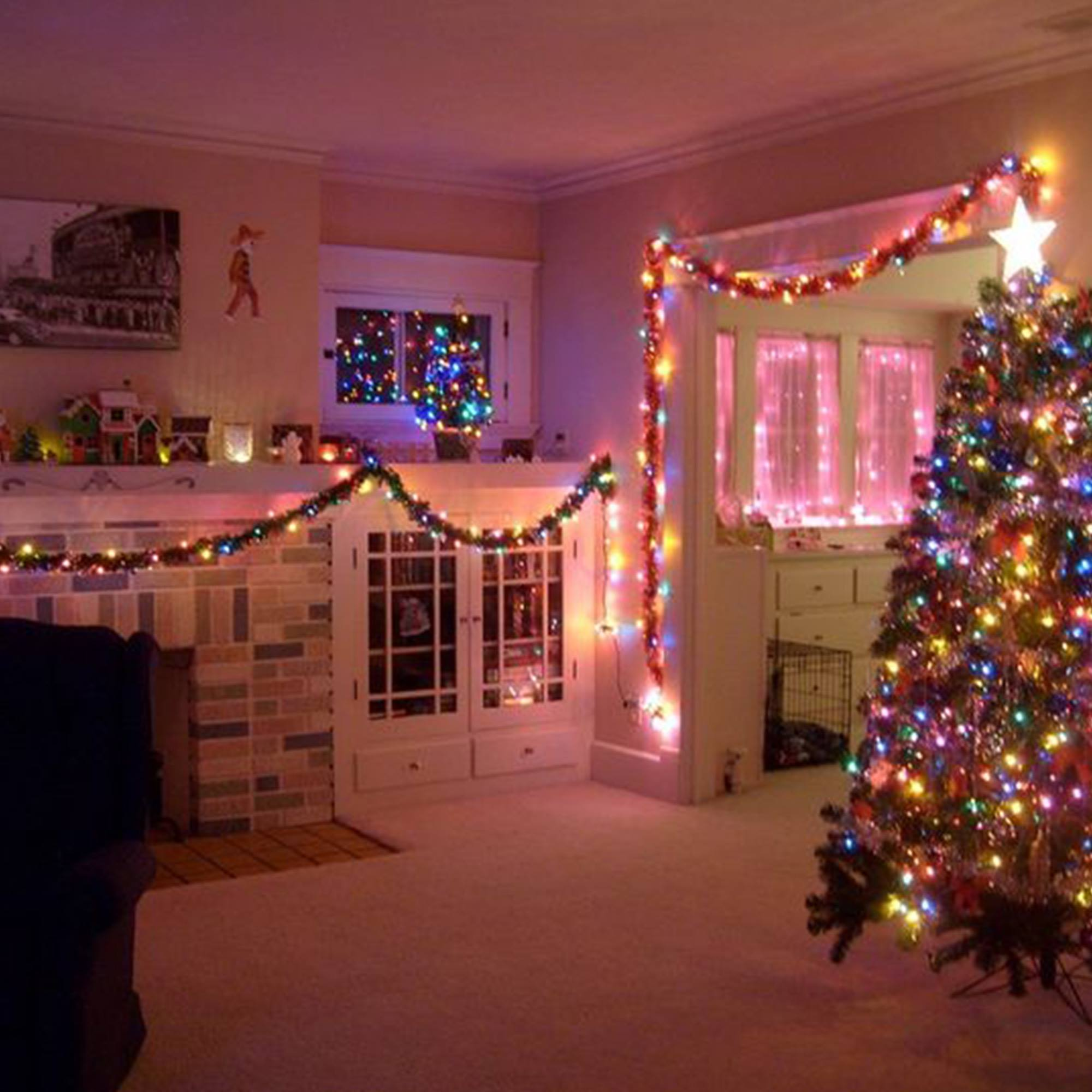 Salón decorado festivamente con árbol de Navidad, luces y guirnalda. Una estrella decora la parte superior del árbol.