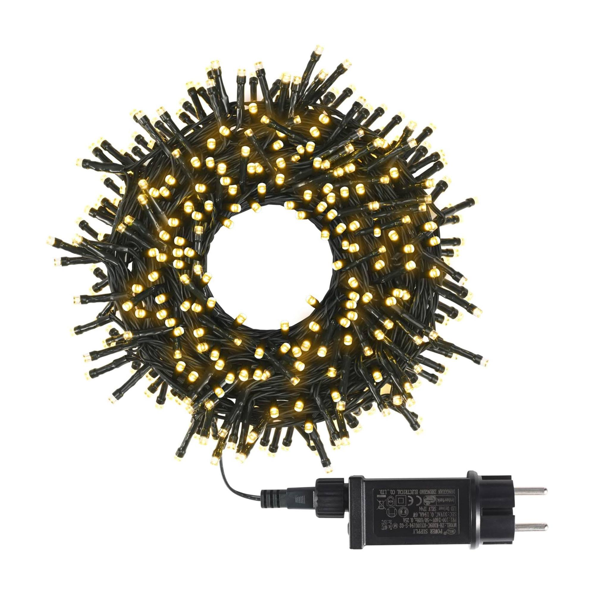 Una disposición circular de luces navideñas con un adaptador de corriente. Las luces son amarillas, sobre cable negro, y el fondo es blanco.