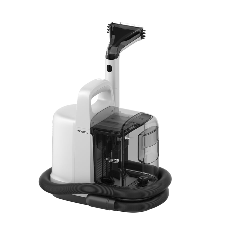 Biało-czarna maszyna do czyszczenia dywanów z uchwytem, wężem i dyszą na białym tle. Czyszczarka ma przezroczysty zbiornik na wodę.