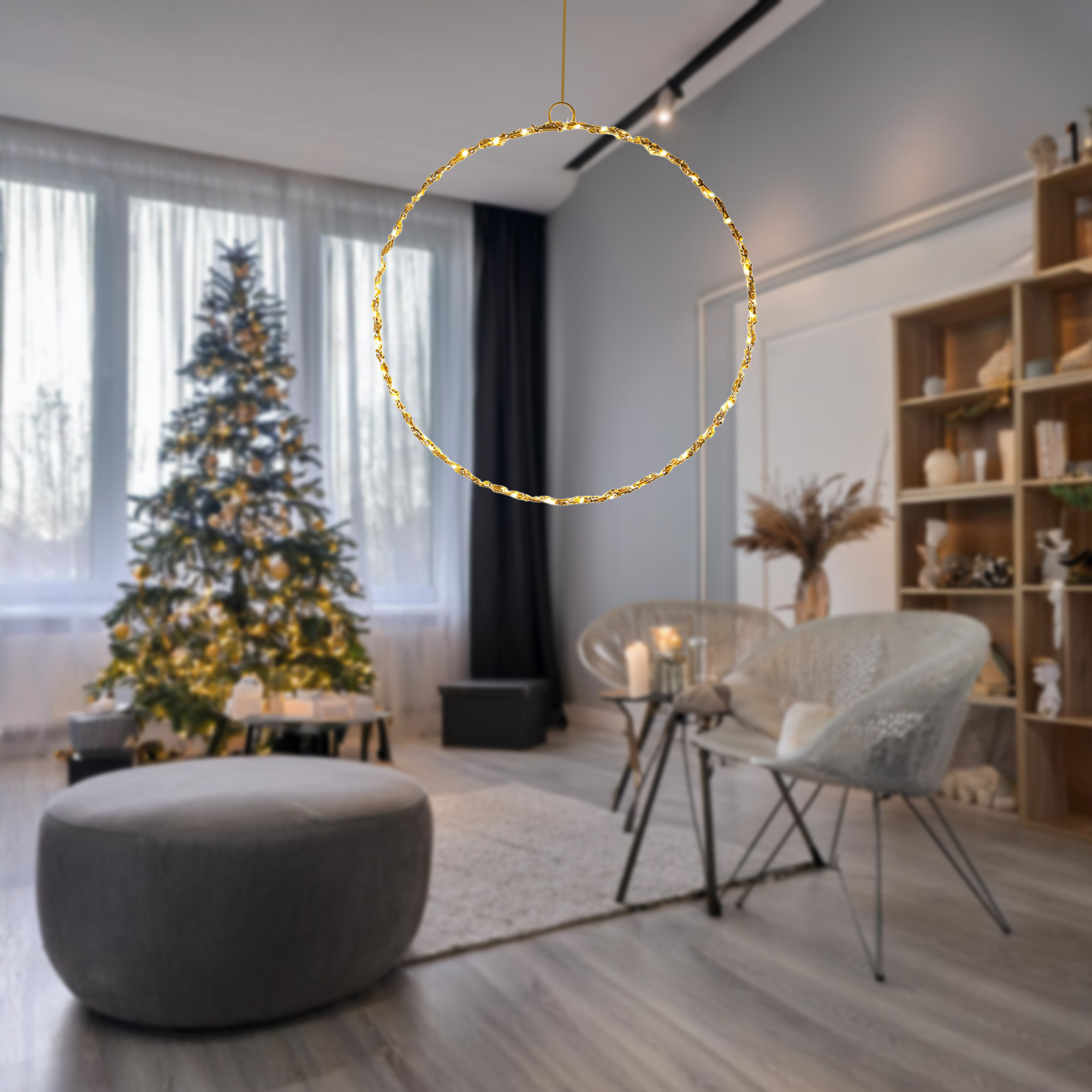 Un aplique dorado en forma de anillo cuelga en una habitación con un árbol de Navidad y zona de estar.