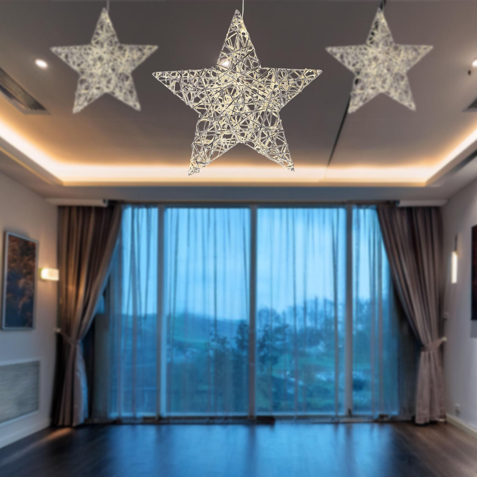 Tres luces en forma de estrella cuelgan del techo. Una gran ventana muestra una escena borrosa al aire libre. La habitación tiene suelo oscuro.