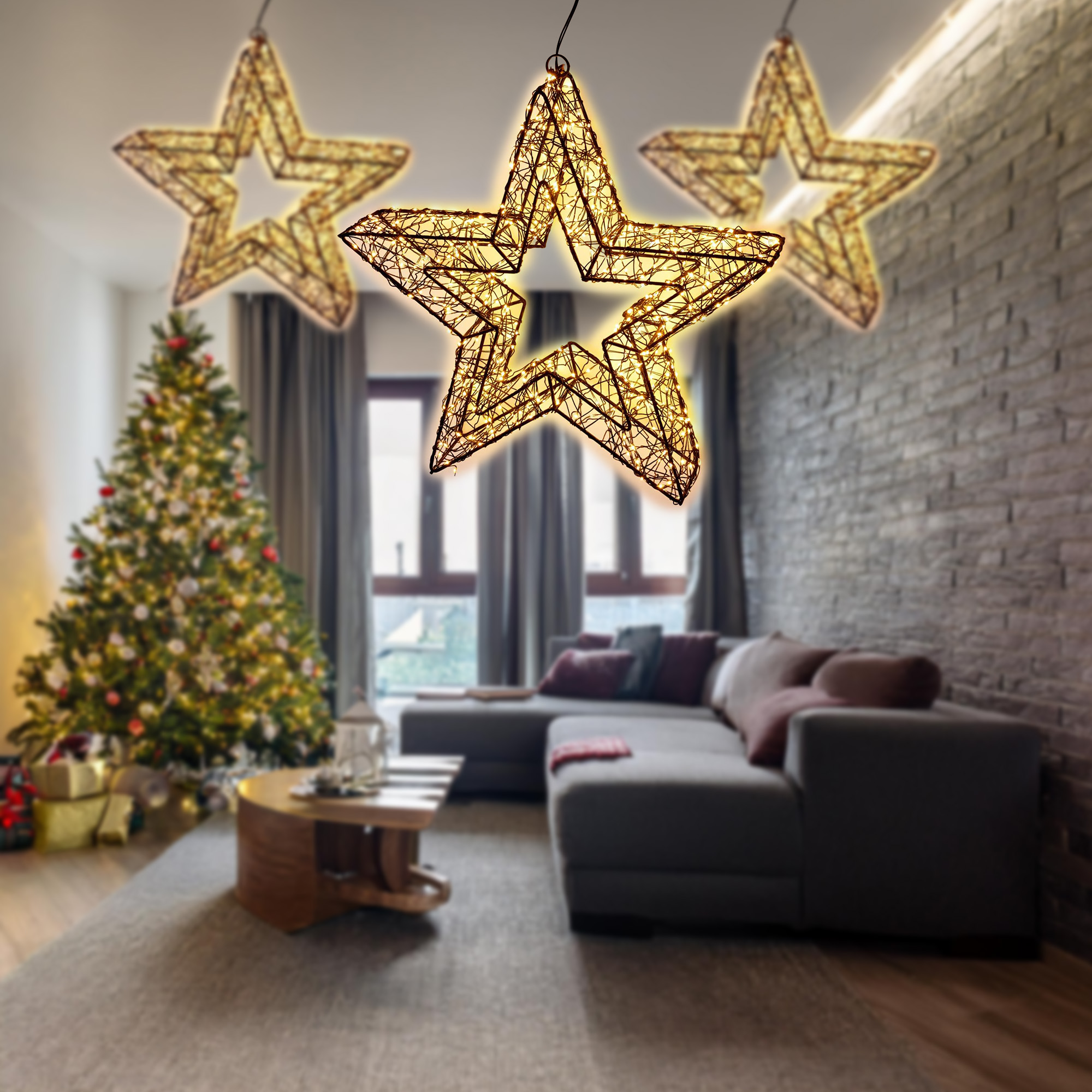 Una sala decorada para Navidad. Adornos de estrellas iluminadas cuelgan del techo. Se ve un árbol de Navidad y un sofá.