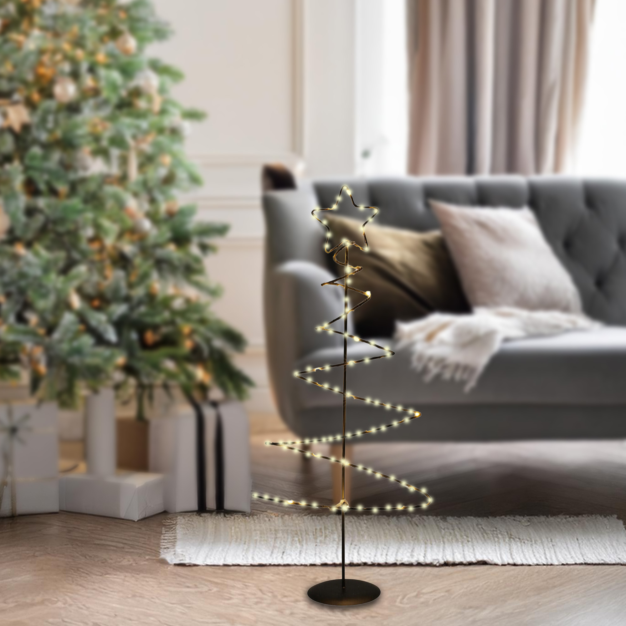 Un árbol de Navidad hecho de luces y una estrella. En el fondo, un árbol de Navidad y un sofá.