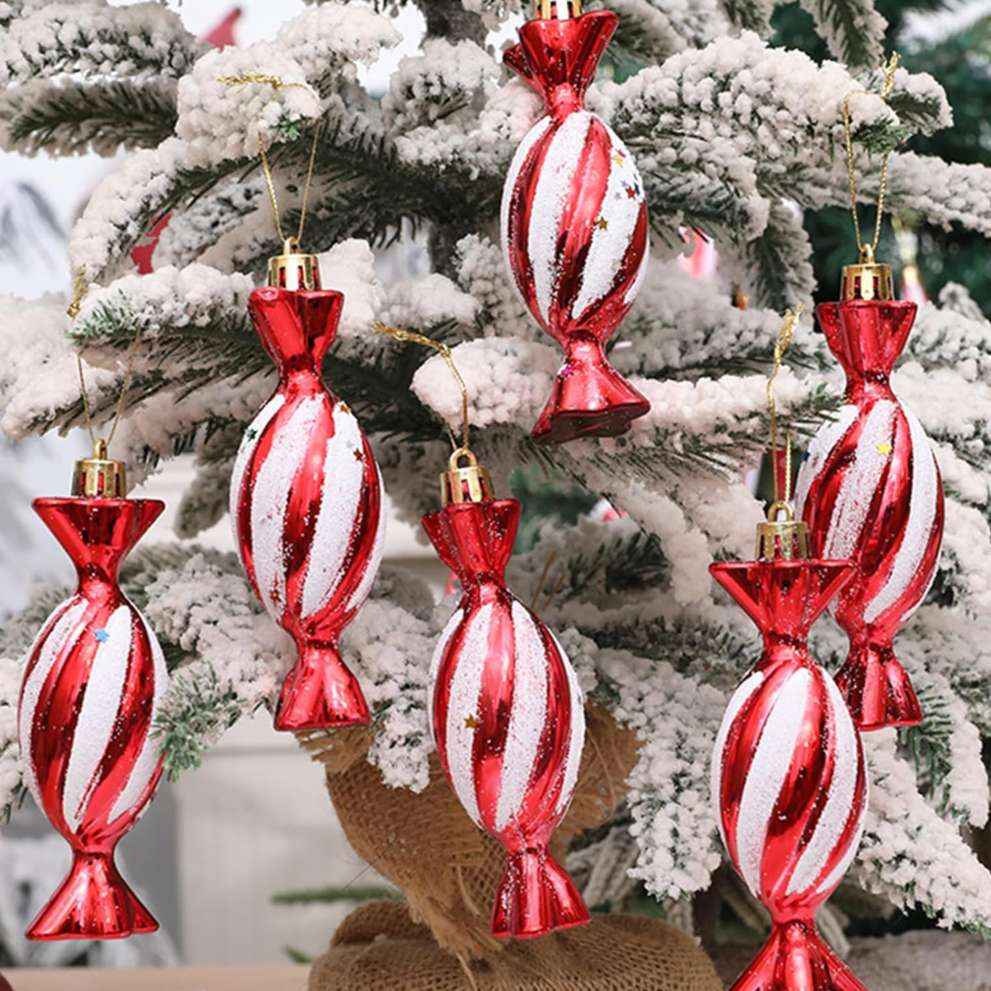 Árbol de Navidad con adornos de caramelos rojos y blancos. El árbol está cubierto de nieve blanca.