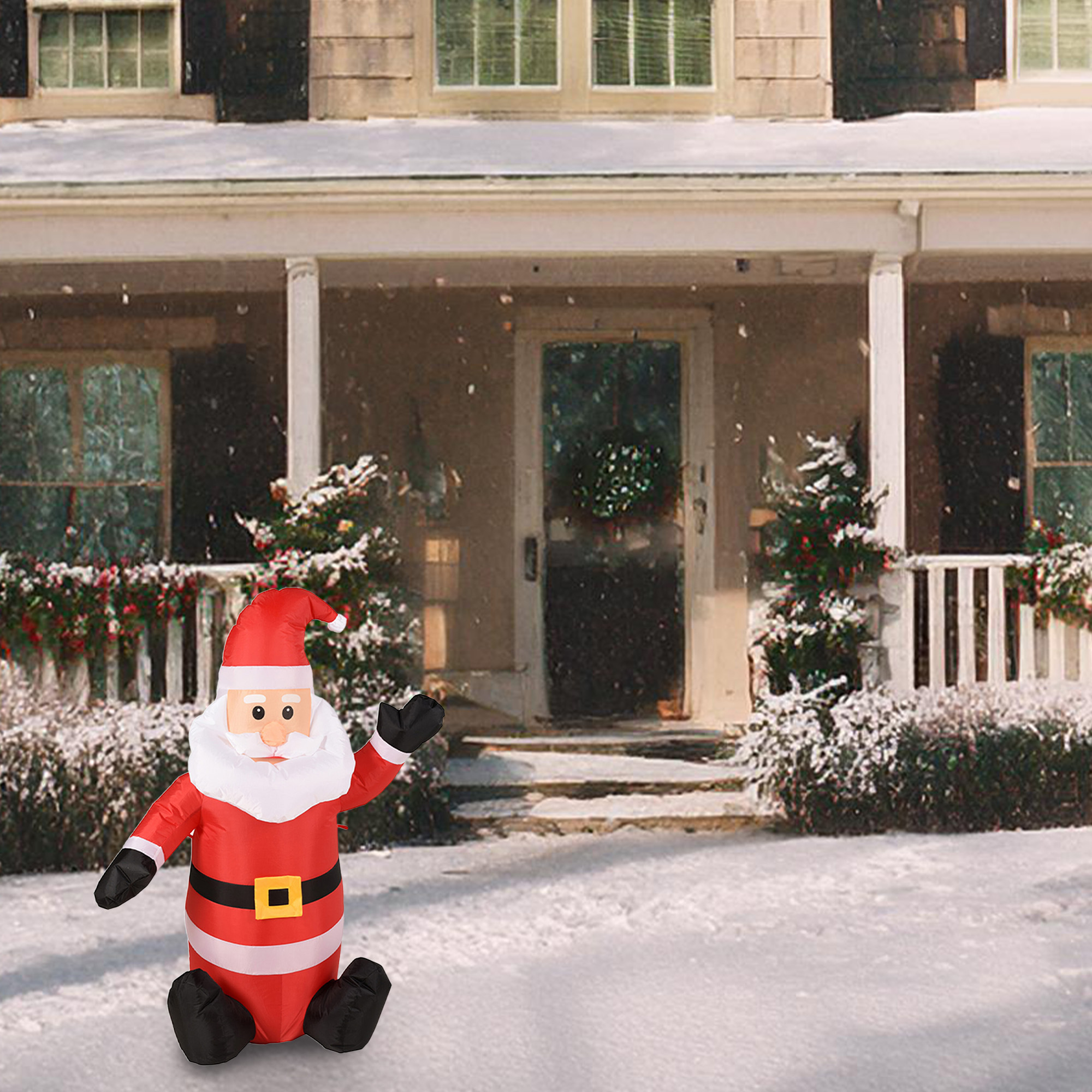 Un Papá Noel inflable frente a una casa cubierta de nieve. El Papá Noel es rojo y negro, con barba y gorro blancos.