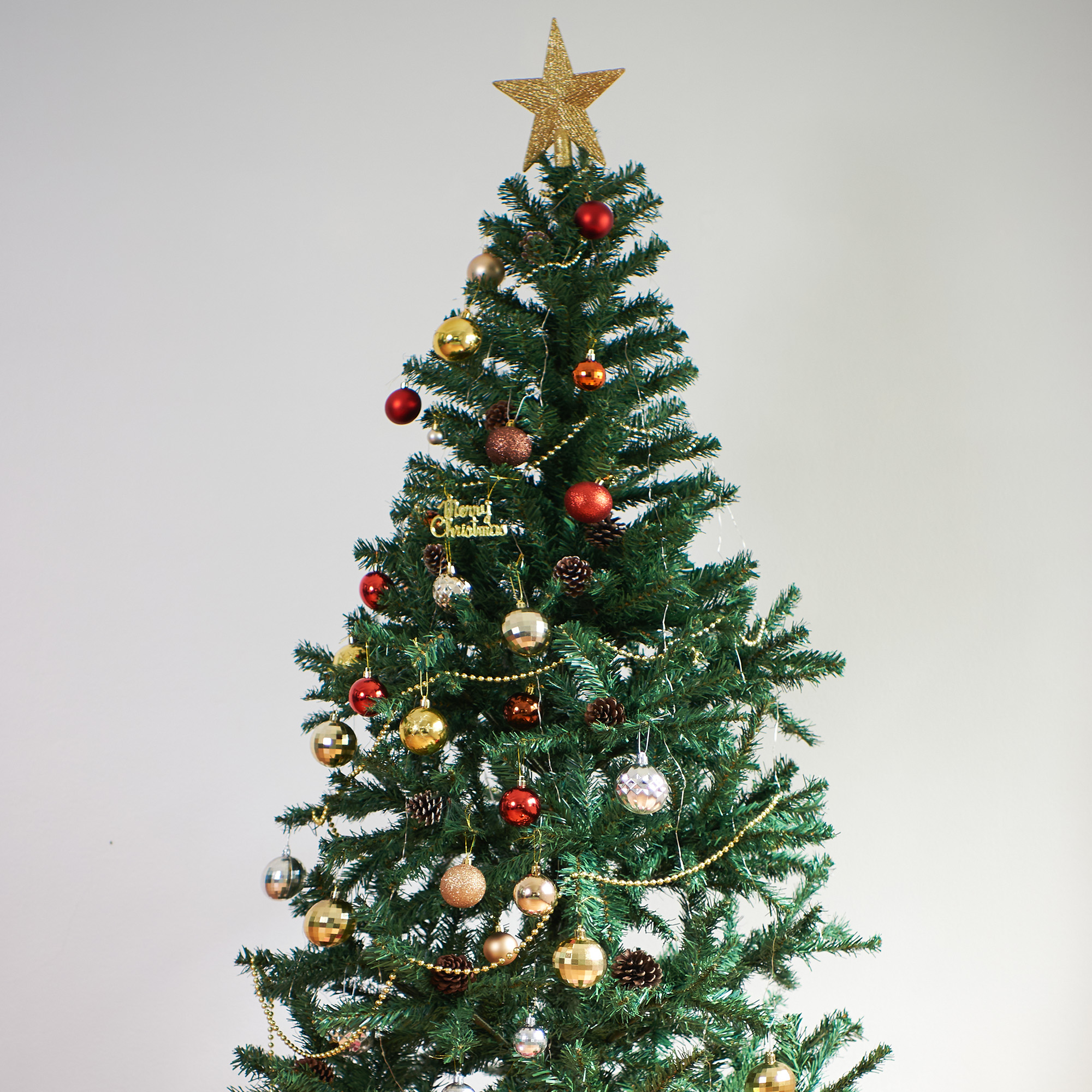 Un árbol de Navidad decorado con adornos, una estrella dorada en la parte superior, sobre un fondo blanco.