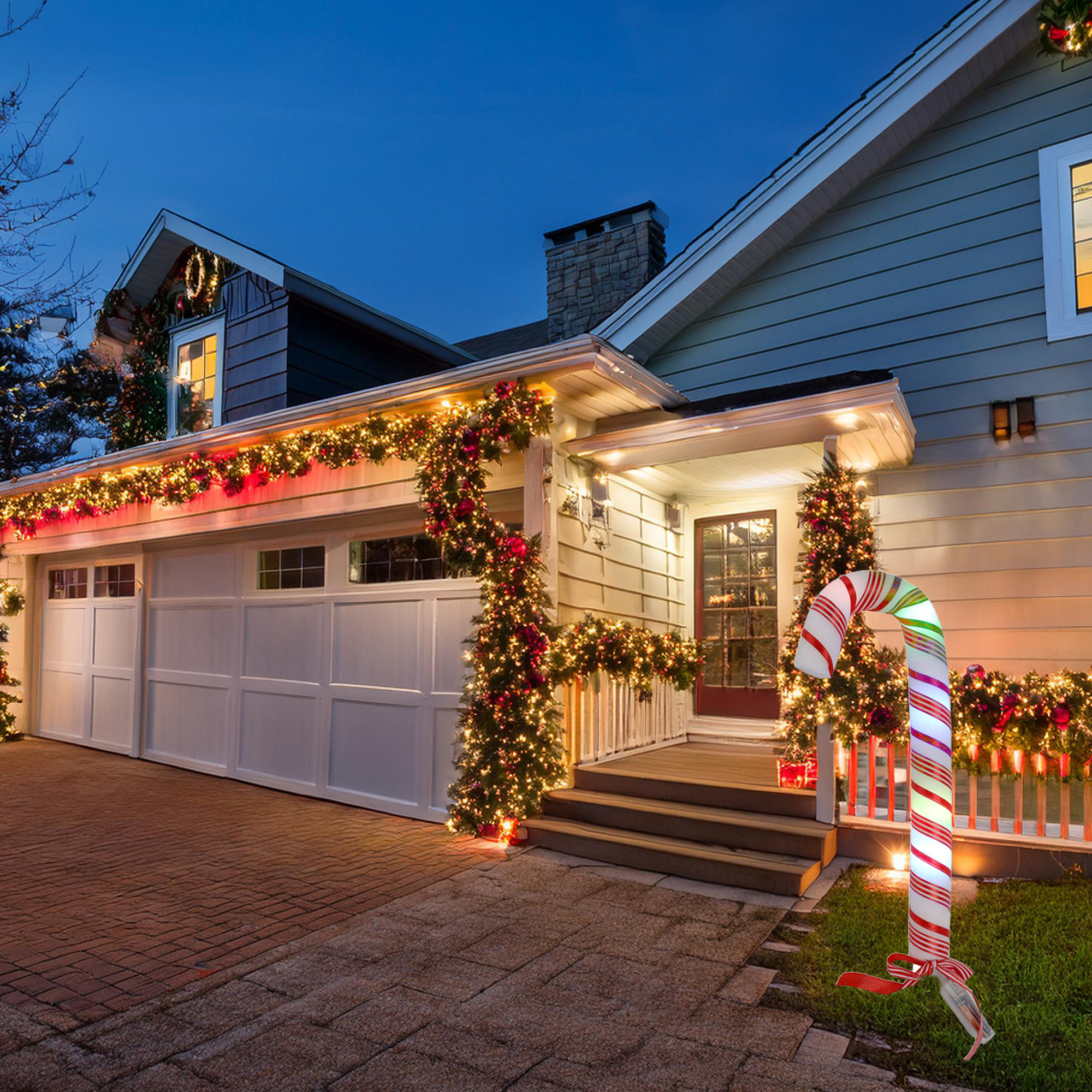 Una casa está decorada para Navidad. Hay un bastón de caramelo en el jardín, luces y guirnaldas.