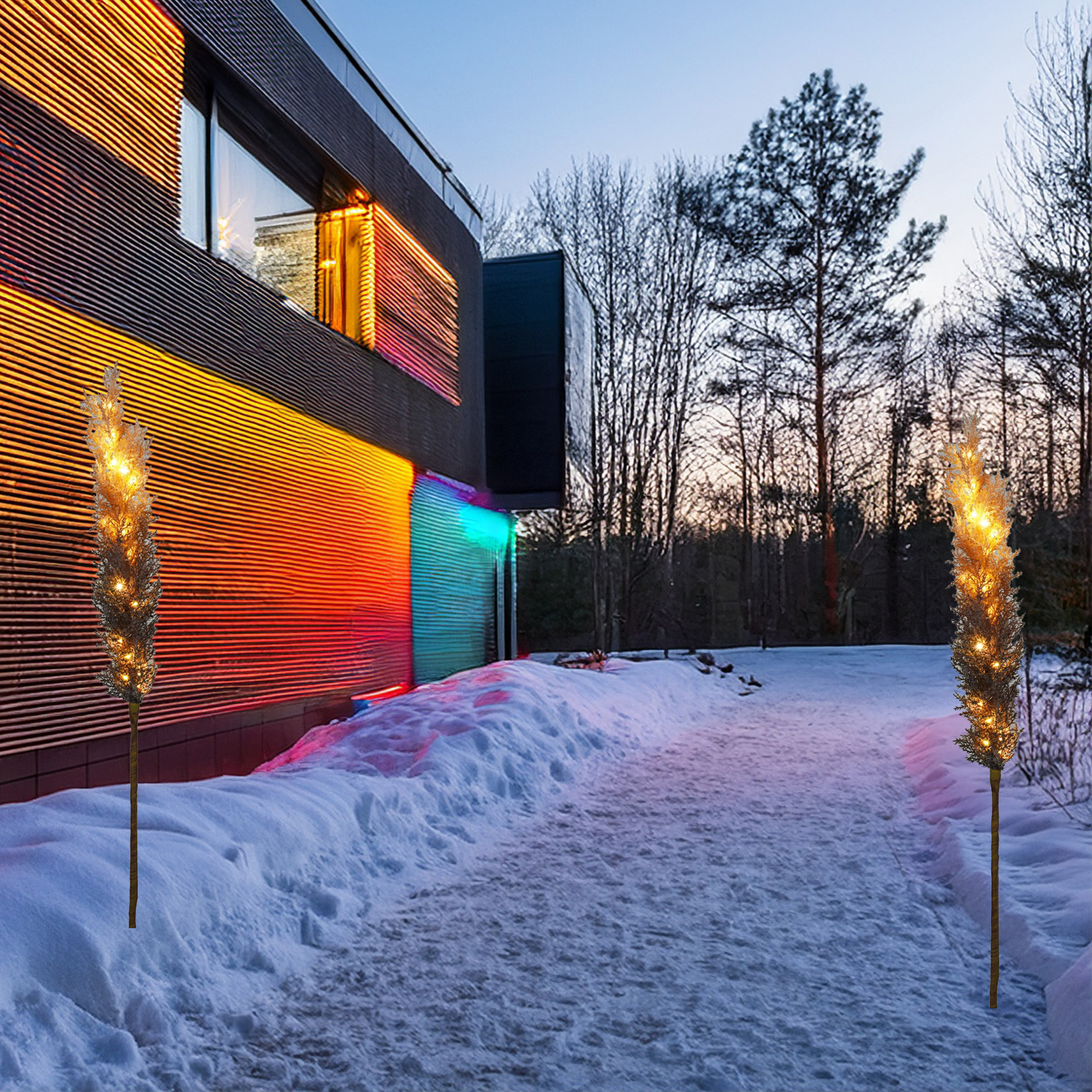 Un edificio moderno con luces de colores y dos luces decorativas en un camino nevado. Los árboles son visibles en el fondo.