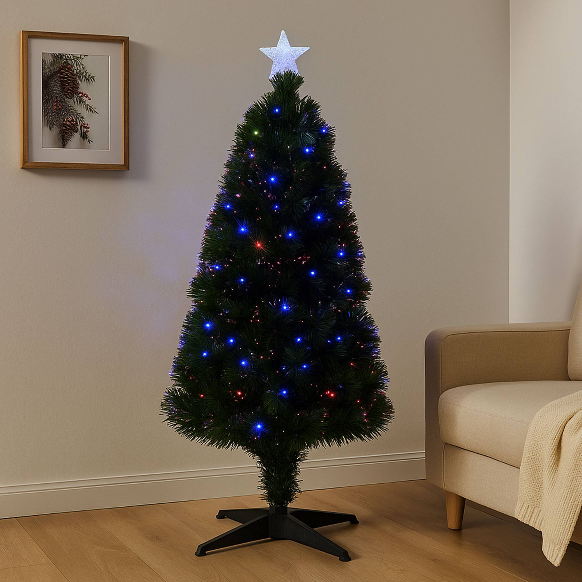 Un árbol de Navidad con luces azules y rojas y una estrella encima. Hay un cuadro en la pared. Un sofá está a la derecha.